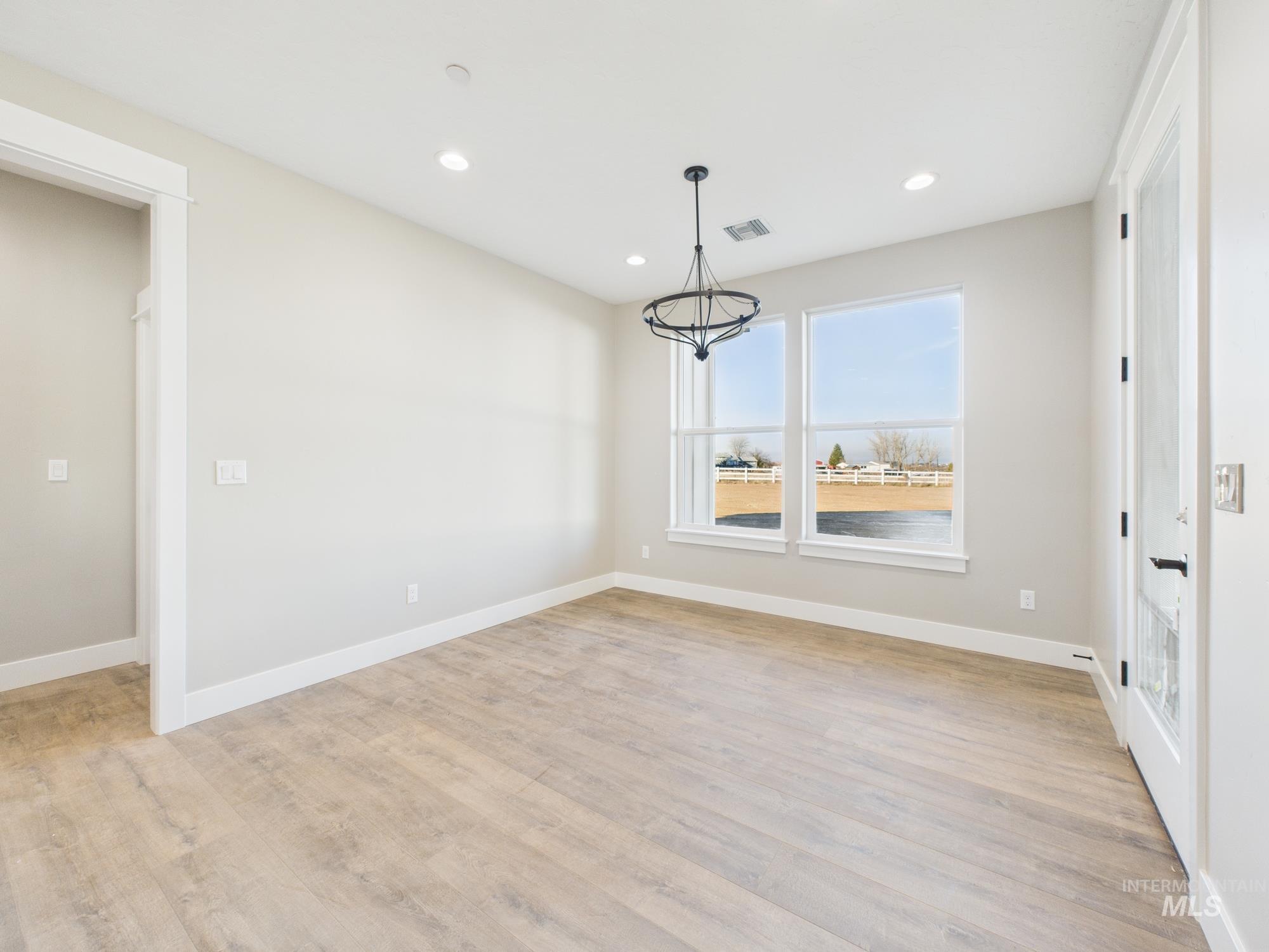 Unfurnished dining area featuring a chandelier, light wood-type flooring, and recessed lighting