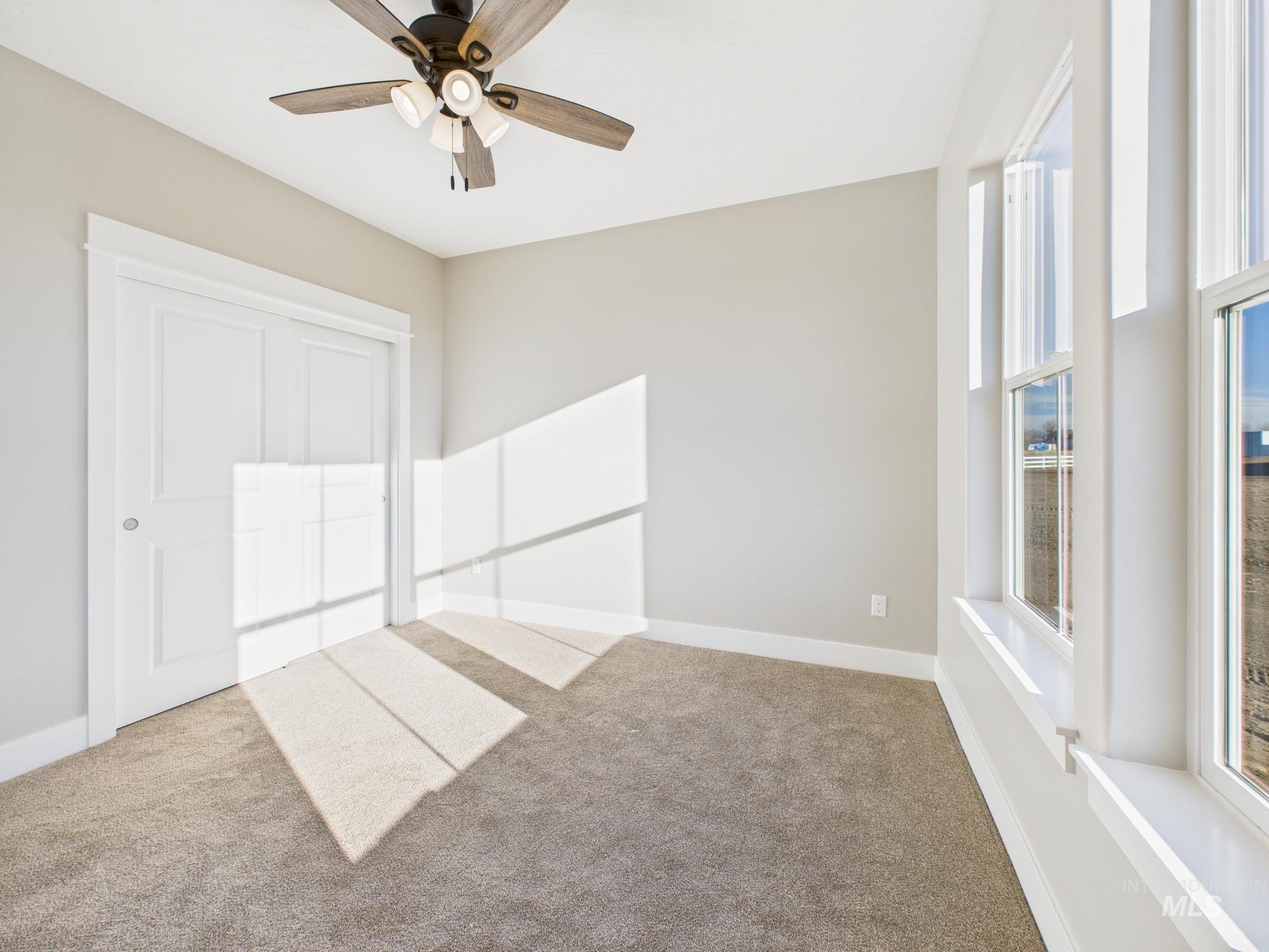 Unfurnished bedroom featuring carpet flooring, ceiling fan, and a closet