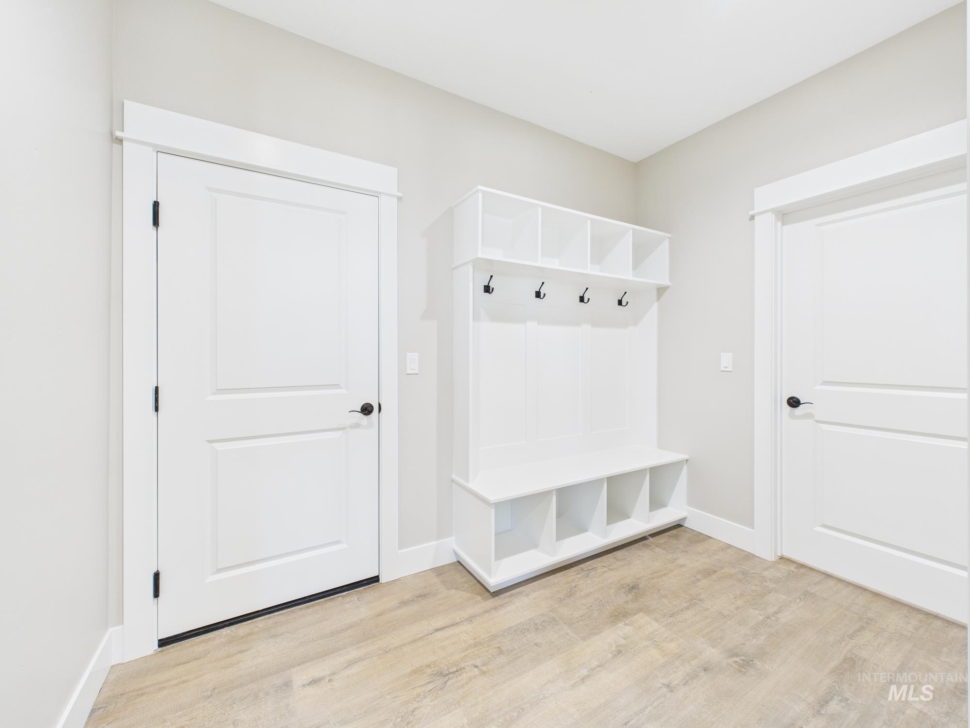 Mudroom with light wood-style flooring and baseboards