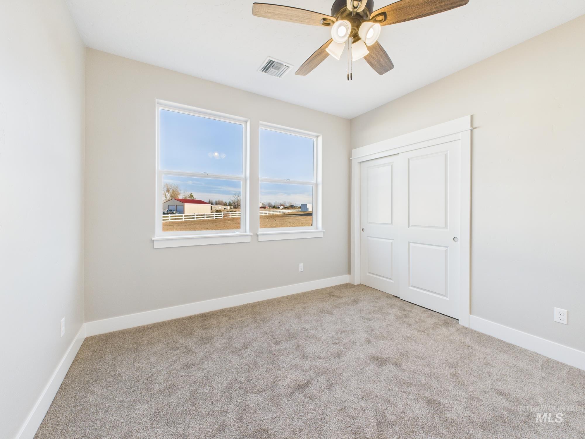 Unfurnished bedroom with light colored carpet, a closet, and a ceiling fan