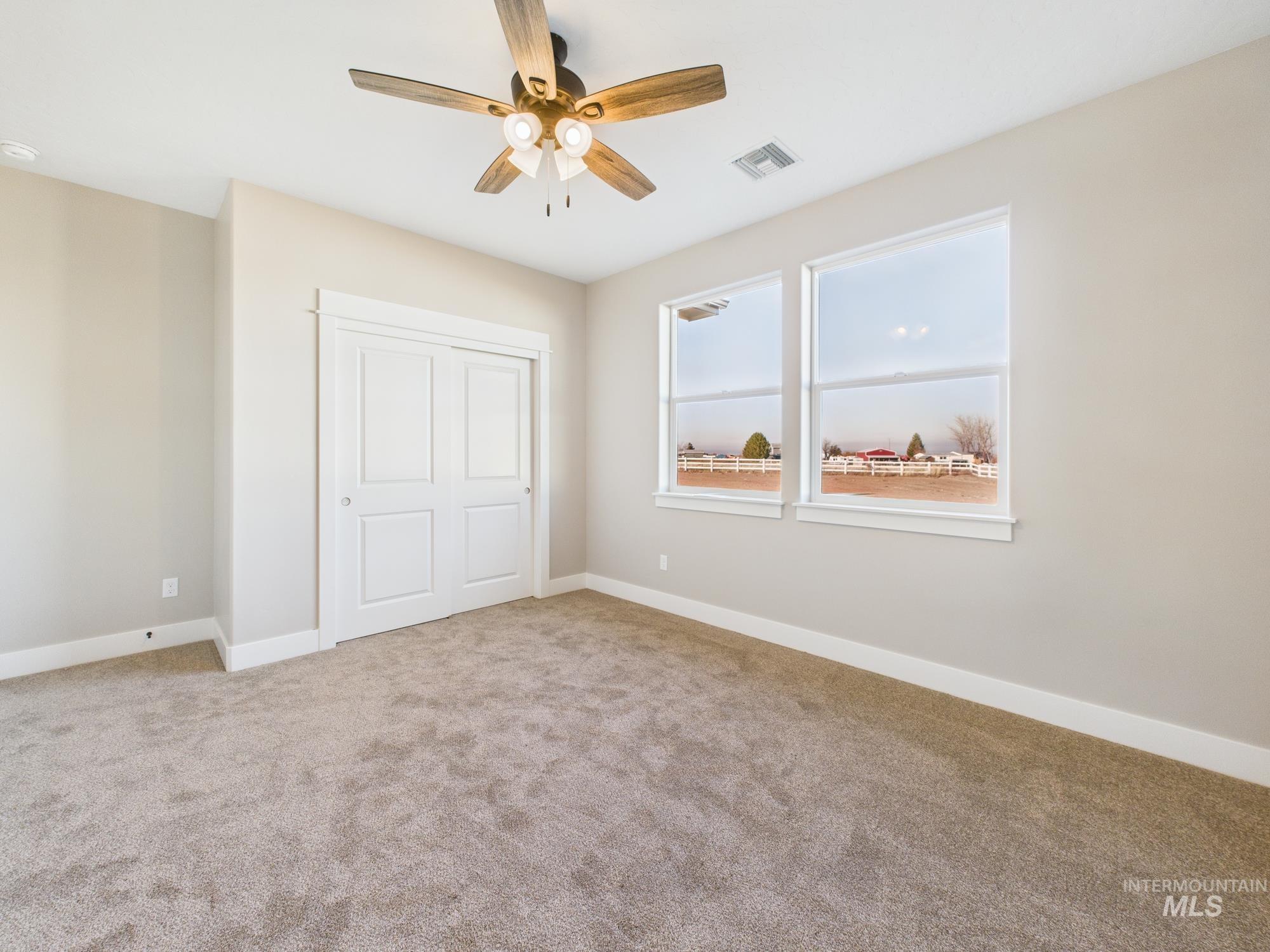 Unfurnished bedroom featuring a closet, a ceiling fan, and light colored carpet