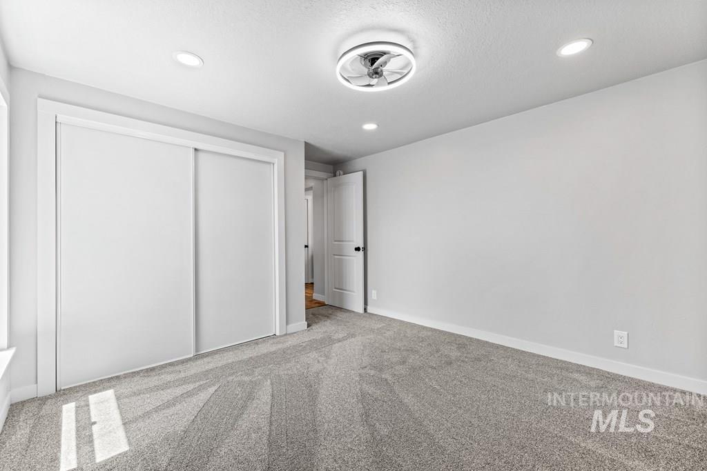Unfurnished bedroom featuring carpet, a closet, recessed lighting, and a textured ceiling