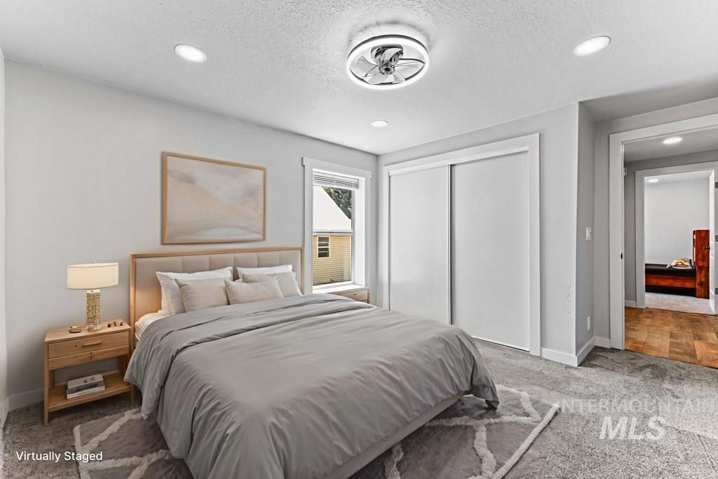 Bedroom with a textured ceiling, a closet, carpet floors, and recessed lighting
