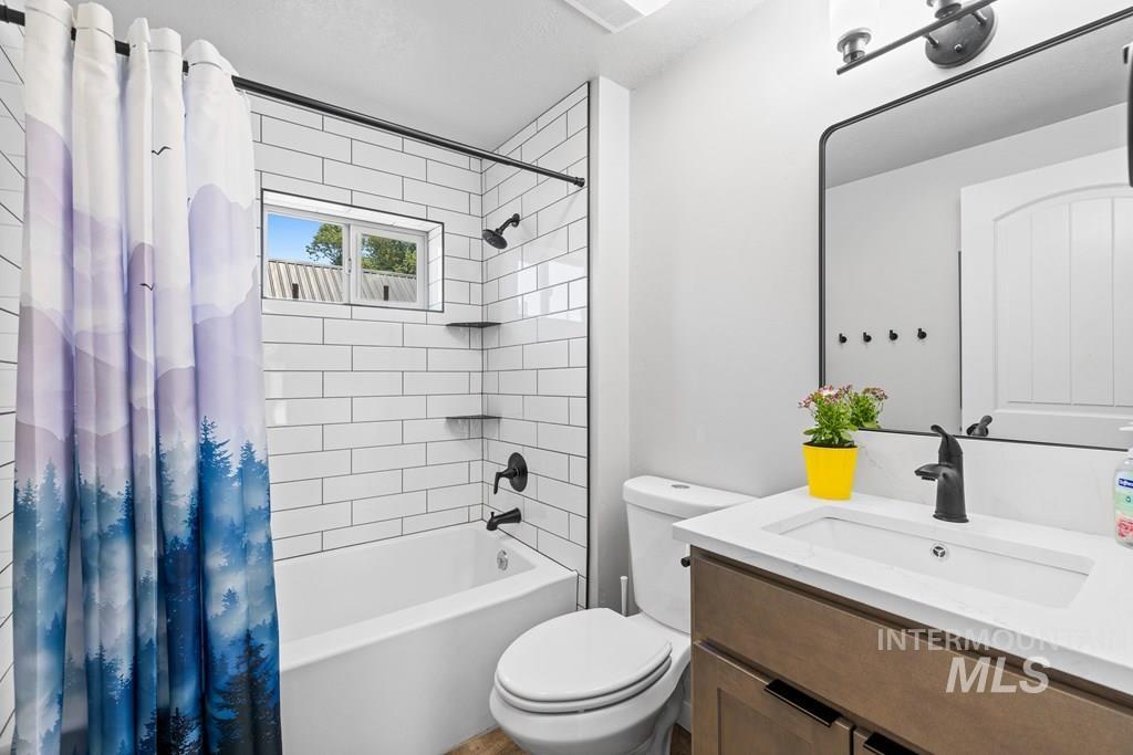 Full bathroom with shower / tub combo with curtain and vanity