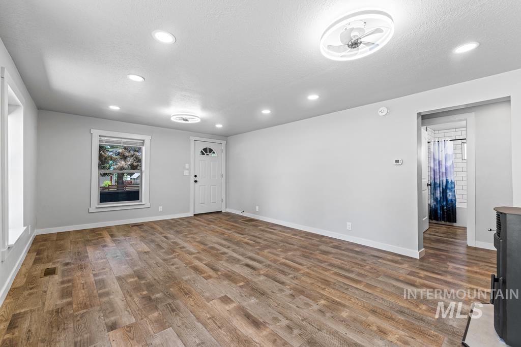 Unfurnished living room with a textured ceiling, wood finished floors, and recessed lighting