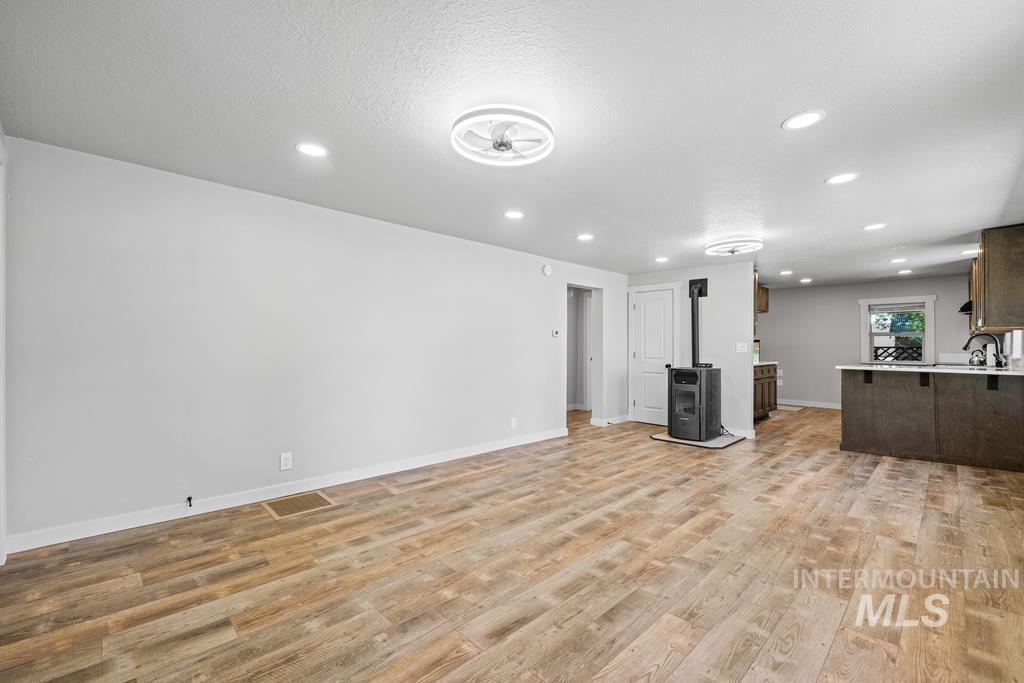 Unfurnished living room featuring light wood-style floors, recessed lighting, and a textured ceiling