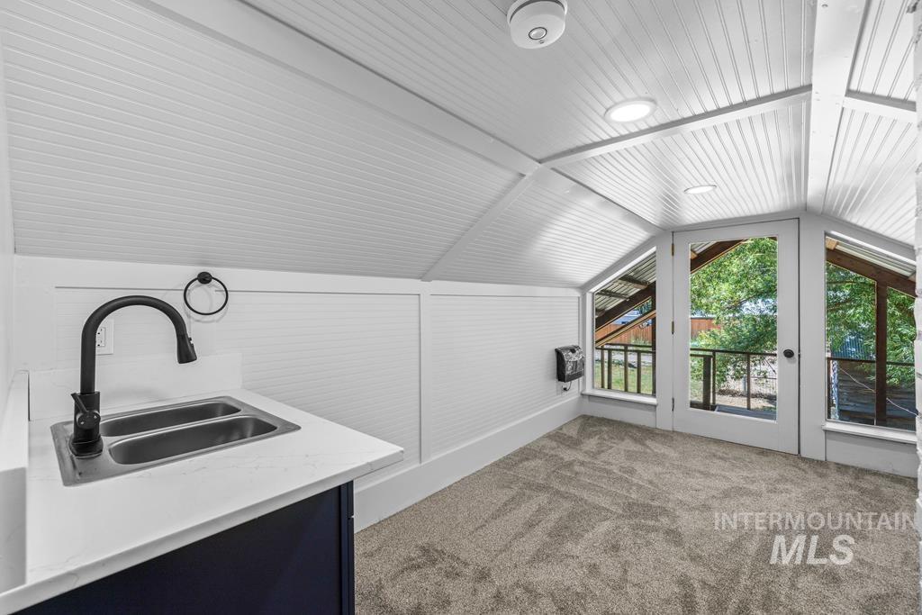 Additional living space with light colored carpet, vaulted ceiling, and heating unit