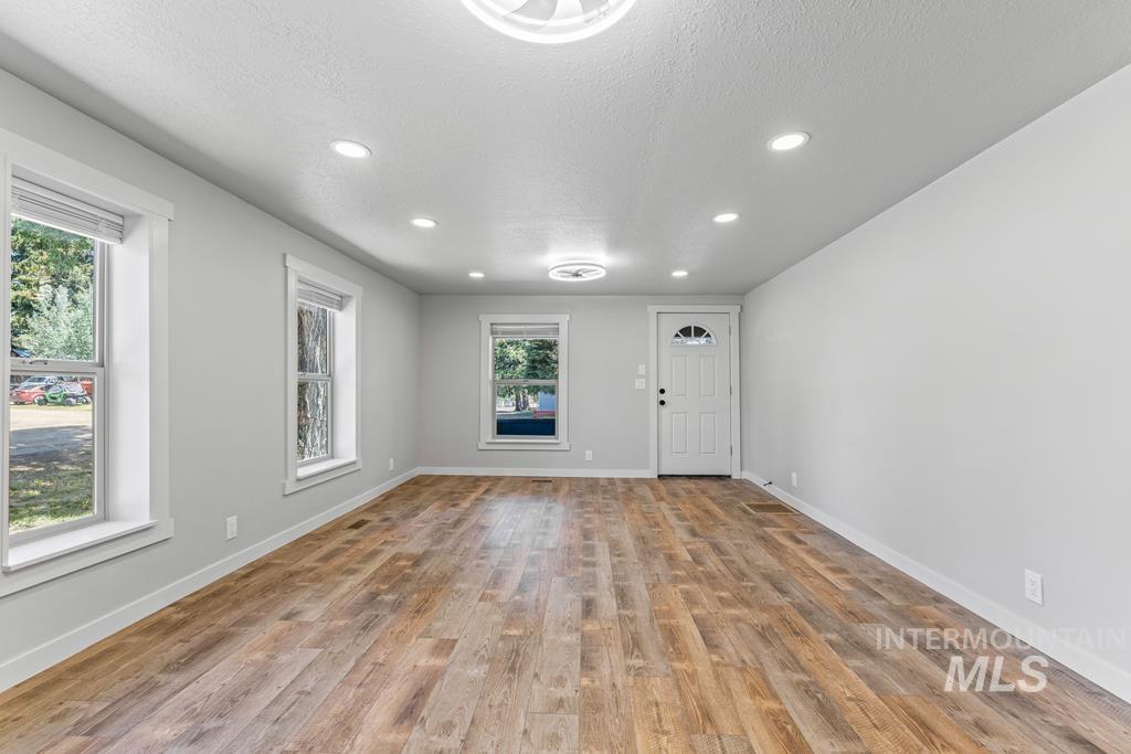 Entrance foyer with a textured ceiling, recessed lighting, and light wood-style floors
