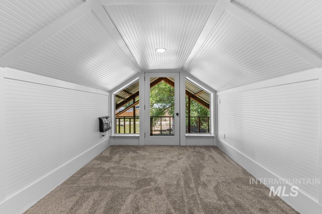 Additional living space with carpet floors, lofted ceiling, and heating unit