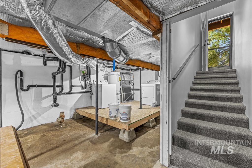Basement with washer / dryer, strapped water heater, and stairs