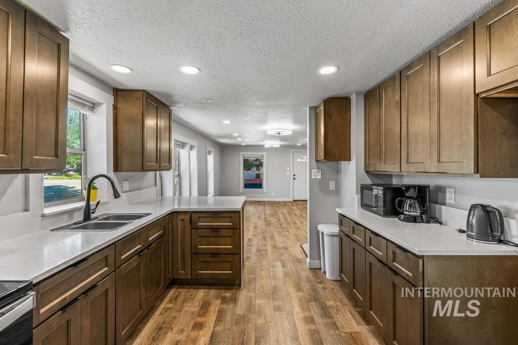 Kitchen featuring recessed lighting, dark wood-type flooring, healthy amount of natural light, a textured ceiling, and black microwave