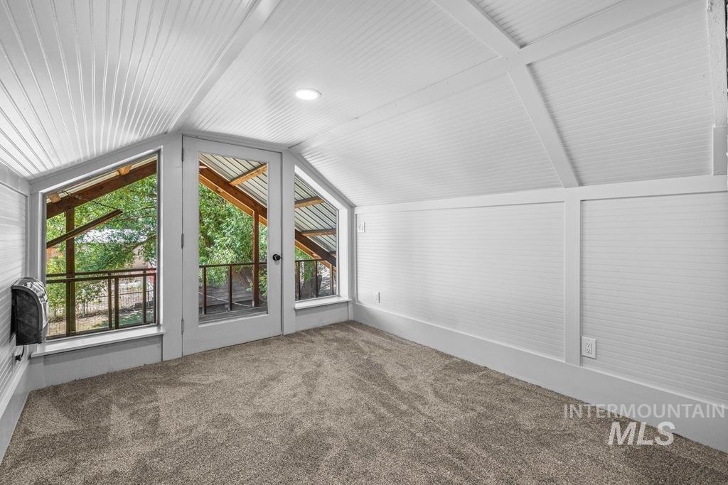 Additional living space featuring lofted ceiling and carpet floors
