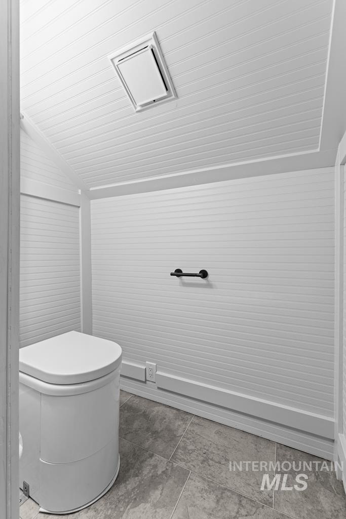 Bathroom with lofted ceiling and toilet