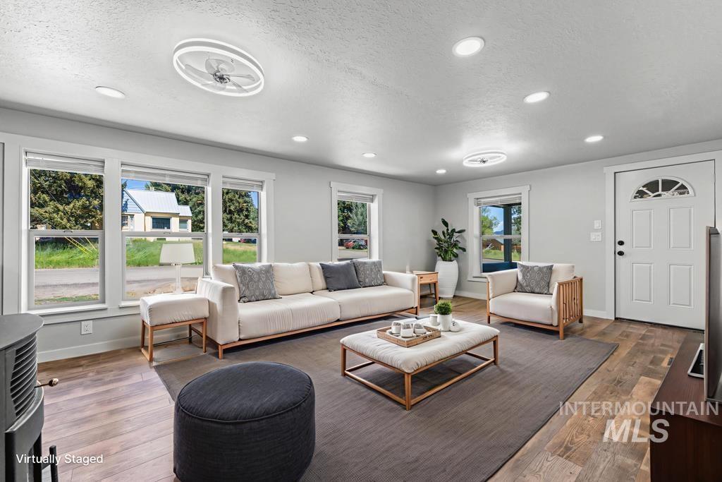 Living room with a textured ceiling, wood finished floors, and recessed lighting