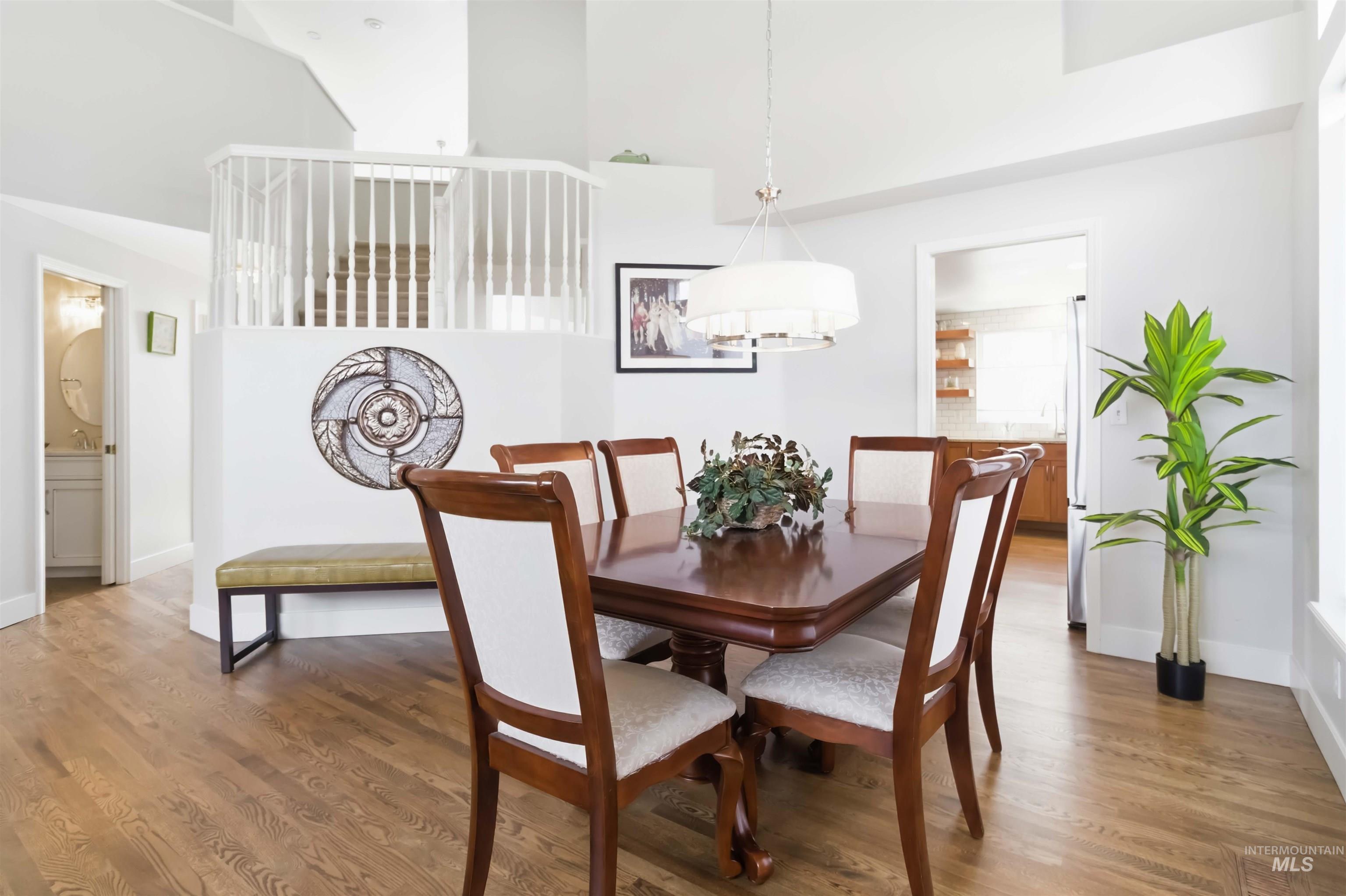 Dining space featuring wood finished floors and a high ceiling
