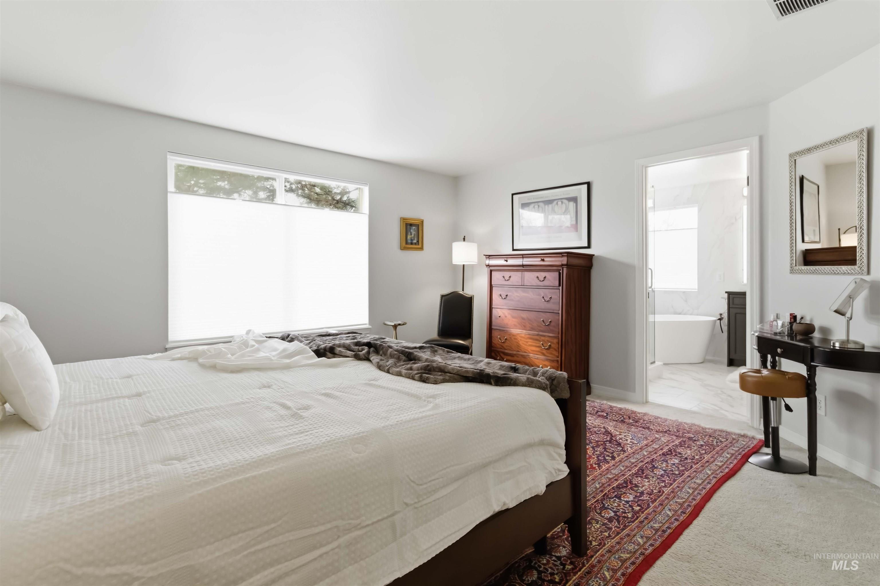 Bedroom with marble finish floors, connected bathroom, and carpet flooring