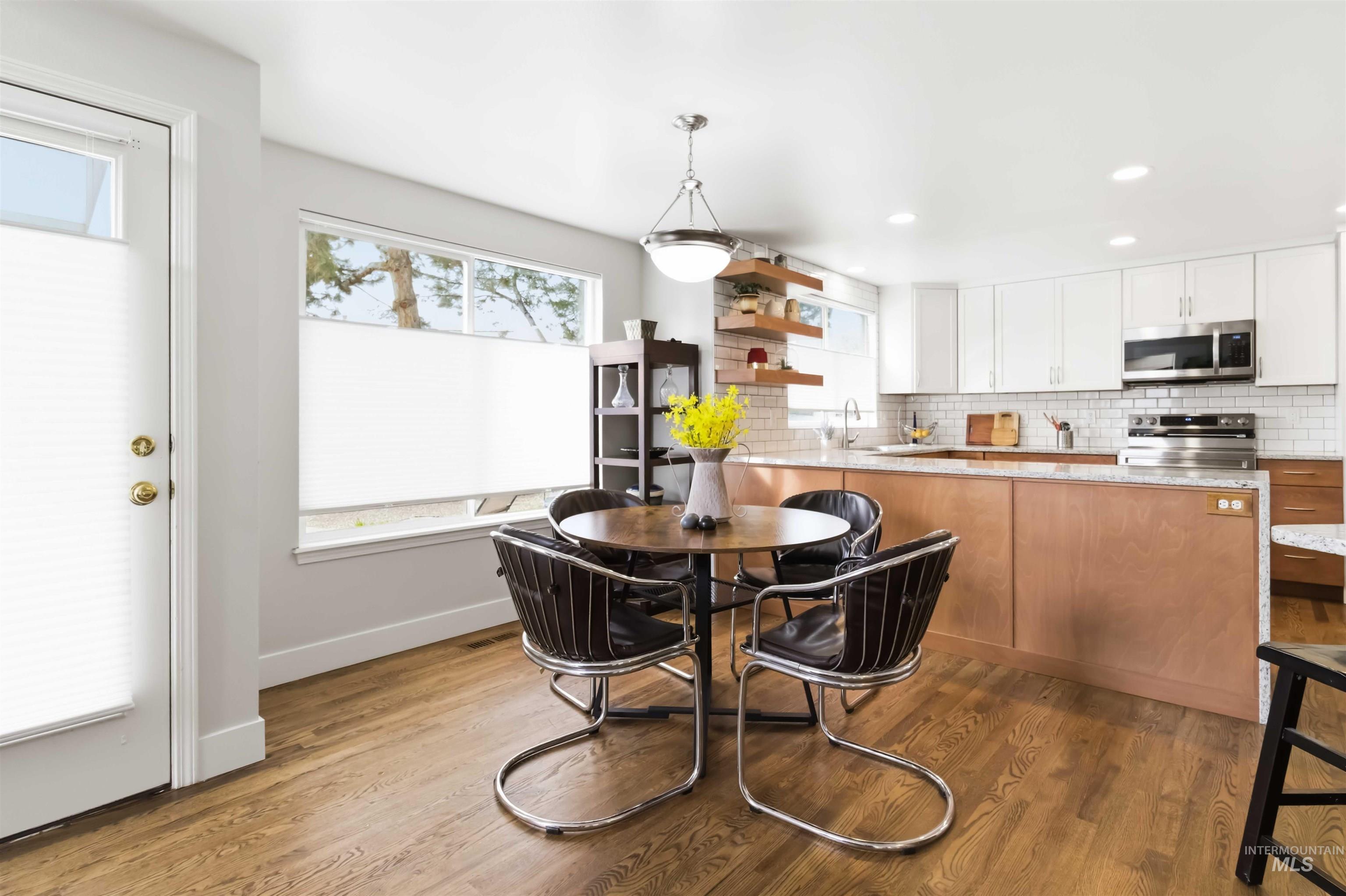 Dining room with dark wood finished floors and recessed lighting