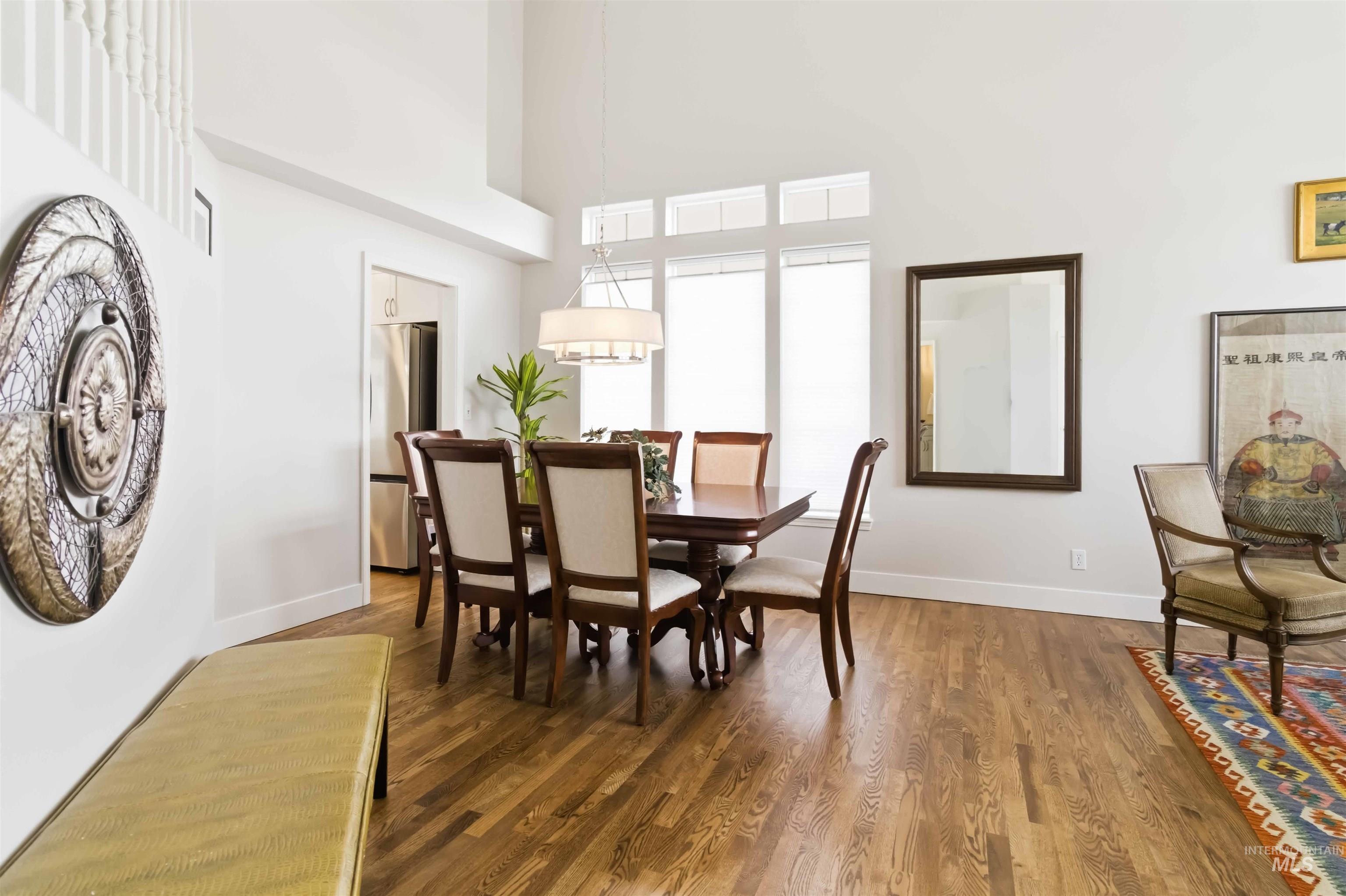 Dining area featuring dark wood-style floors and a high ceiling