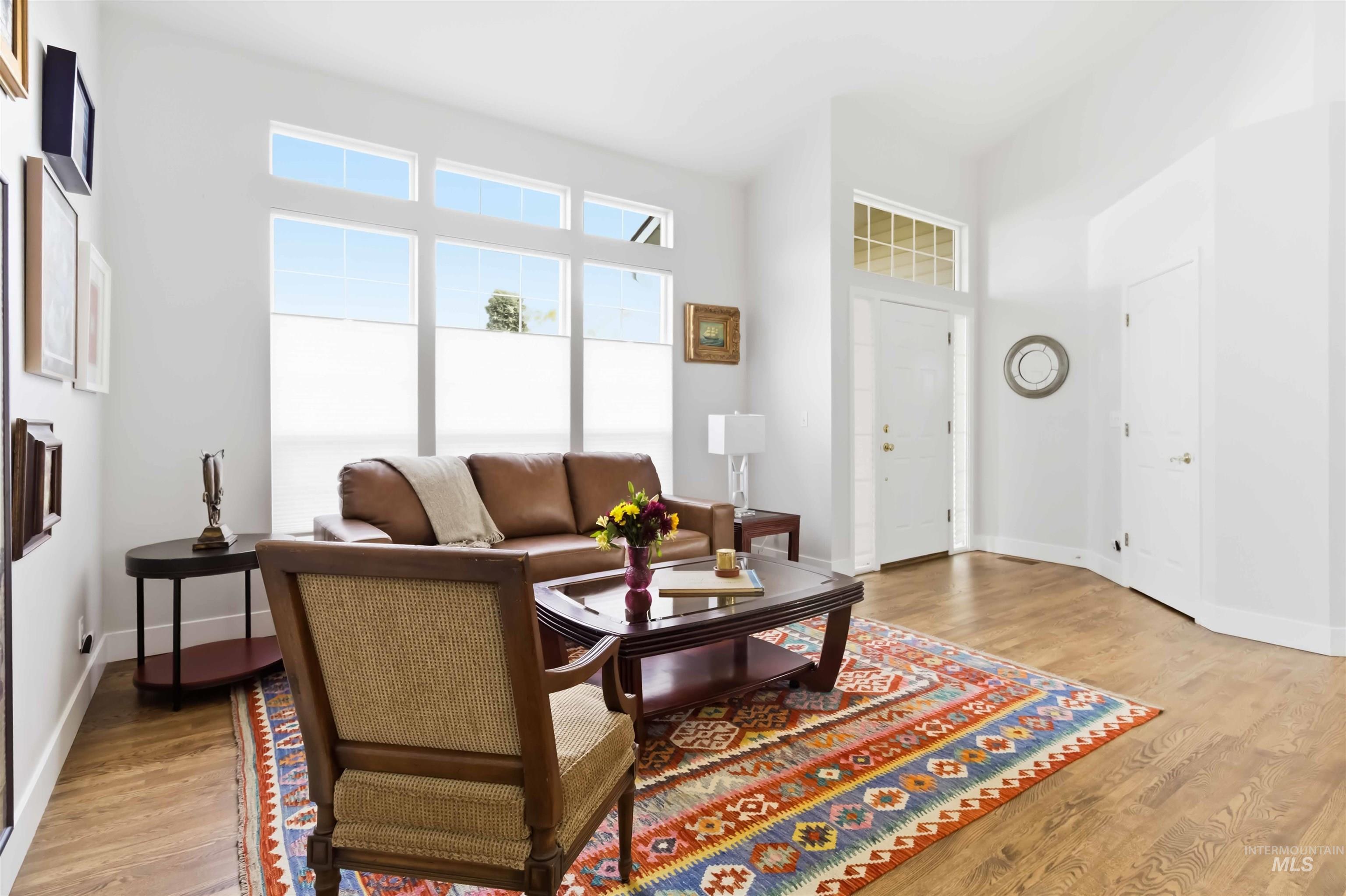 Living area featuring light wood-style flooring and a high ceiling