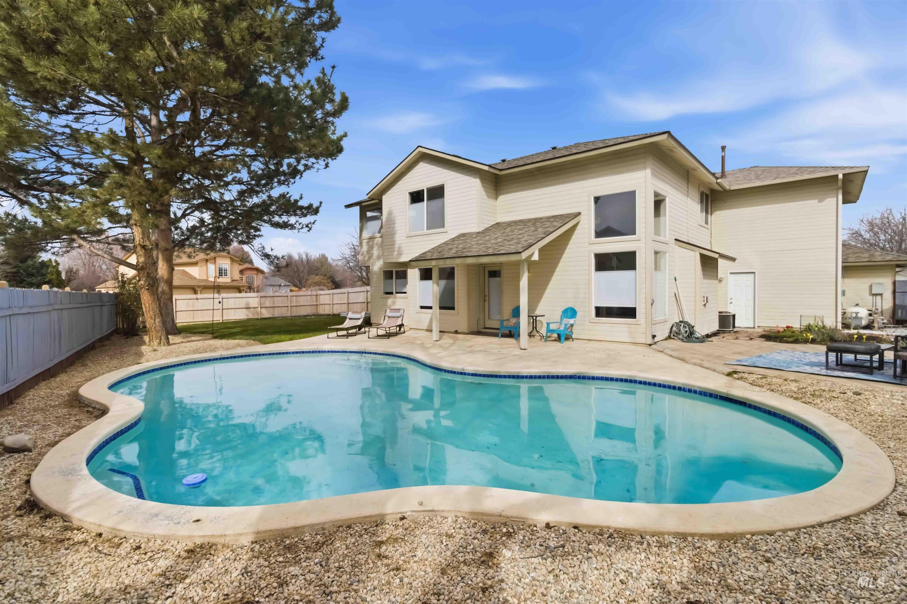 Rear view of property featuring a patio, roof with shingles, and a fenced backyard