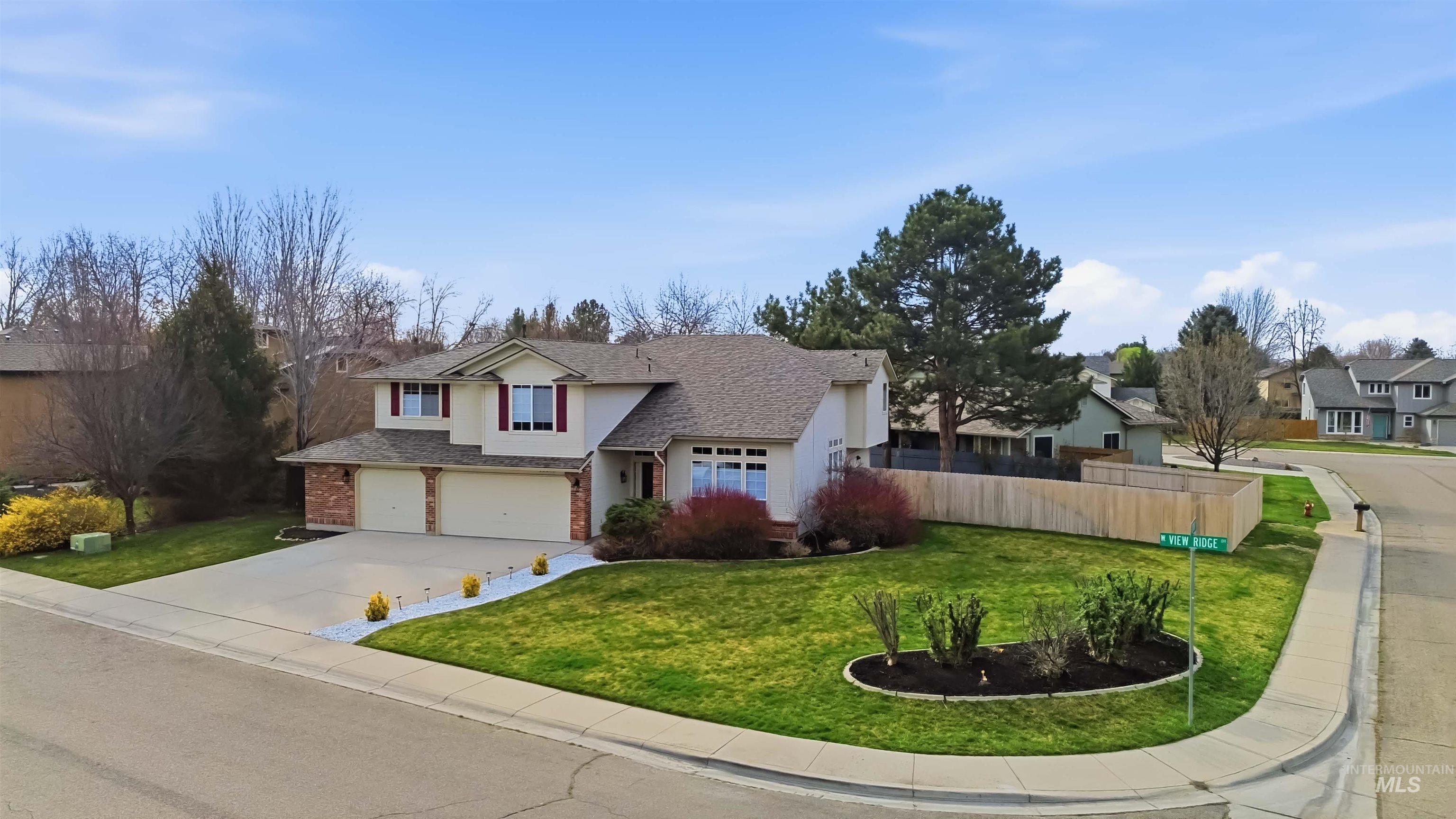 Traditional-style home with stucco siding, a shingled roof, driveway, a residential view, and an attached garage