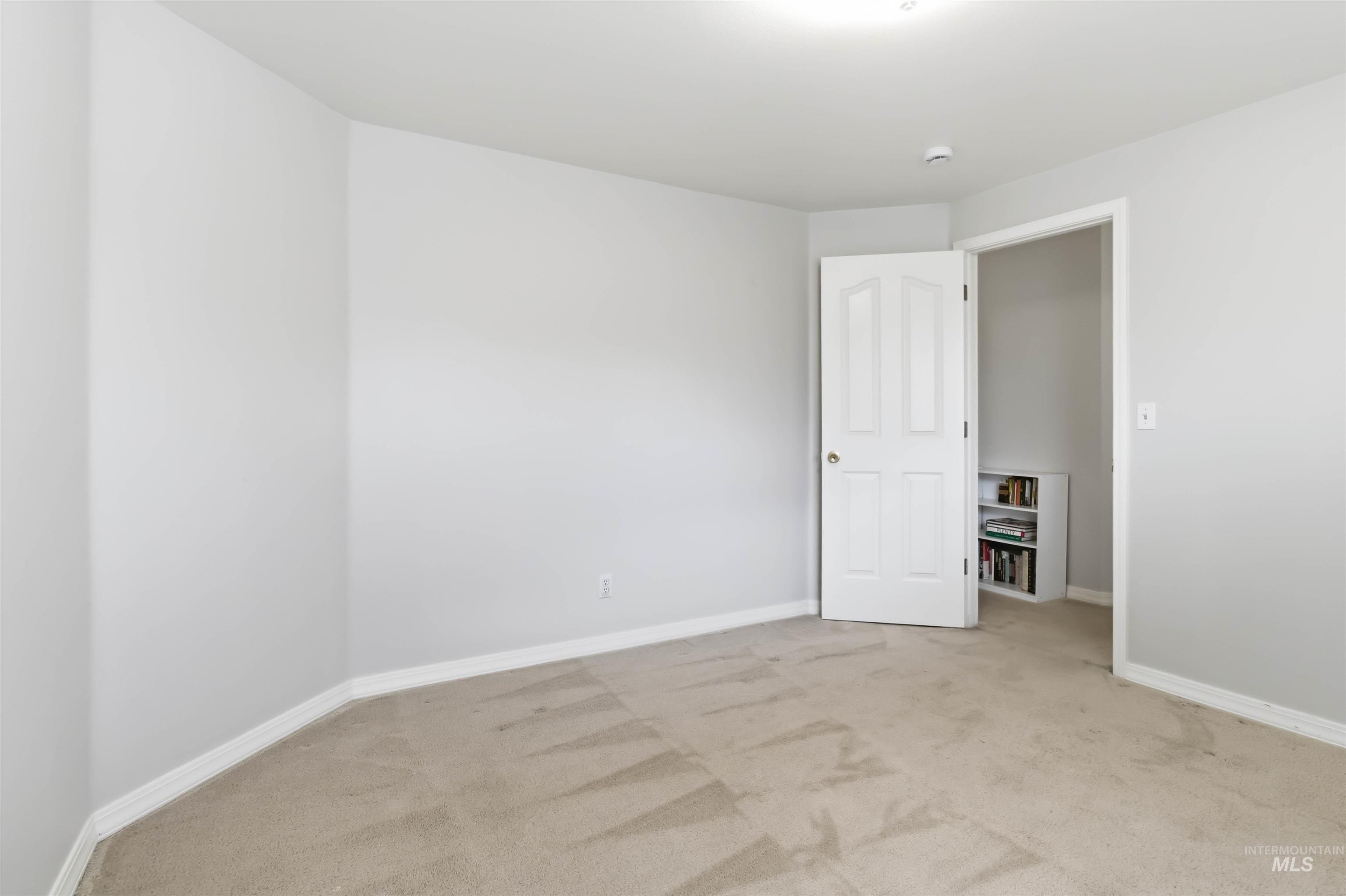 Unfurnished room featuring light colored carpet and baseboards