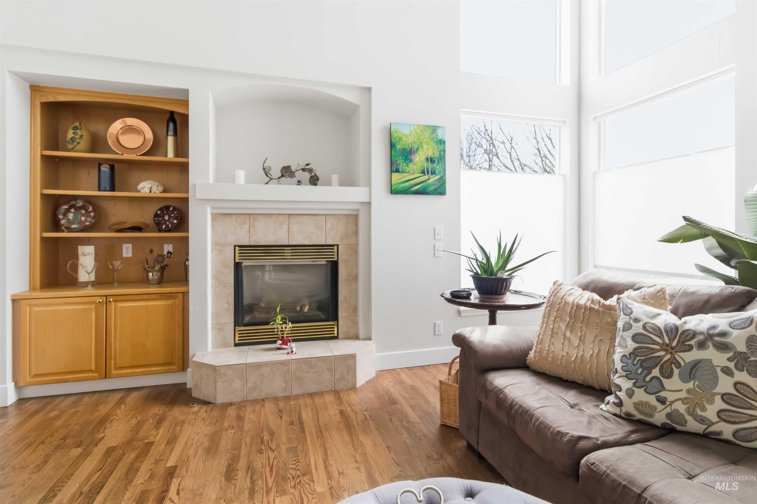 Living area featuring wood finished floors, a fireplace, and built in shelves