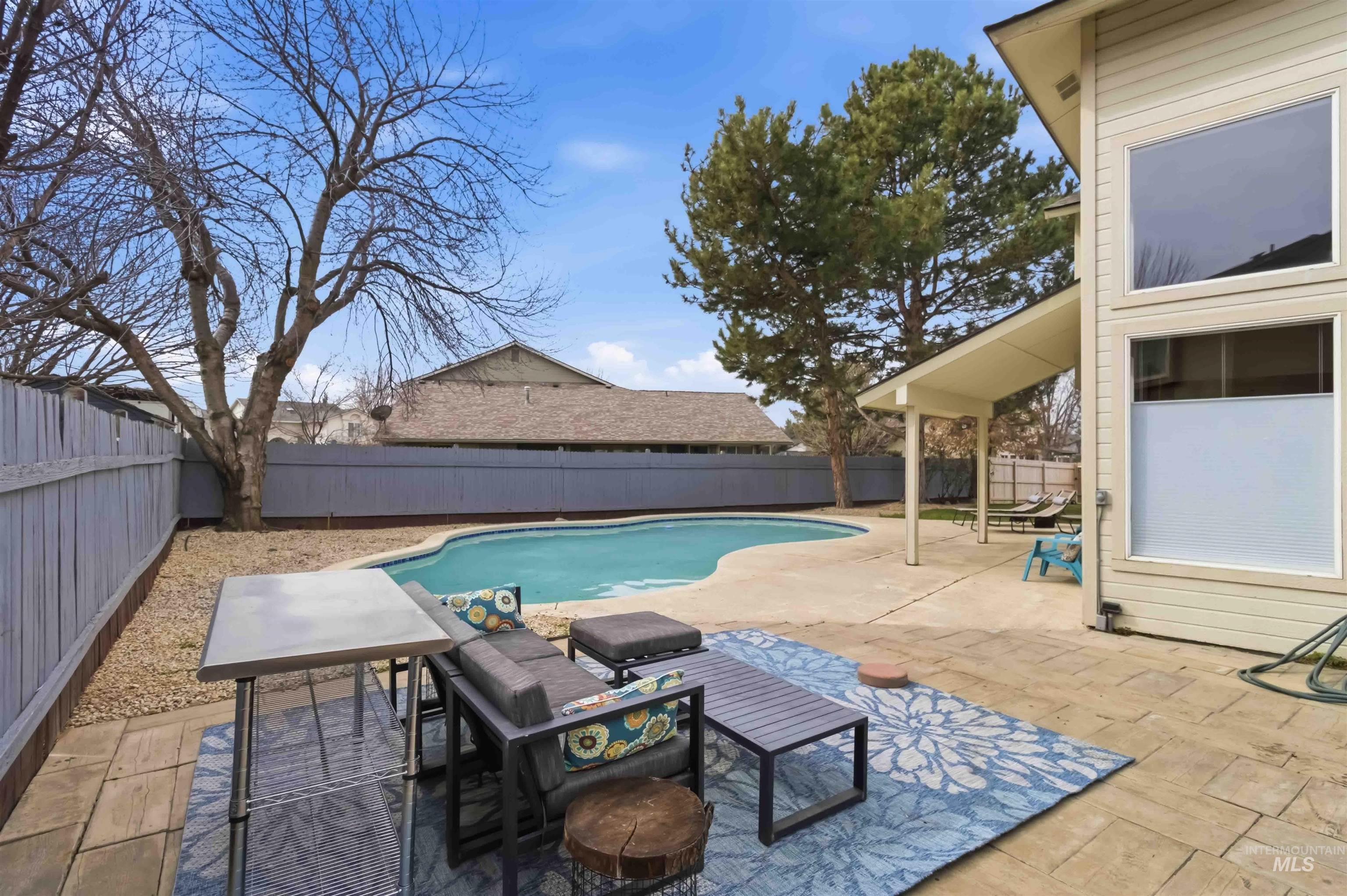 View of swimming pool with patio surround and a fenced backyard