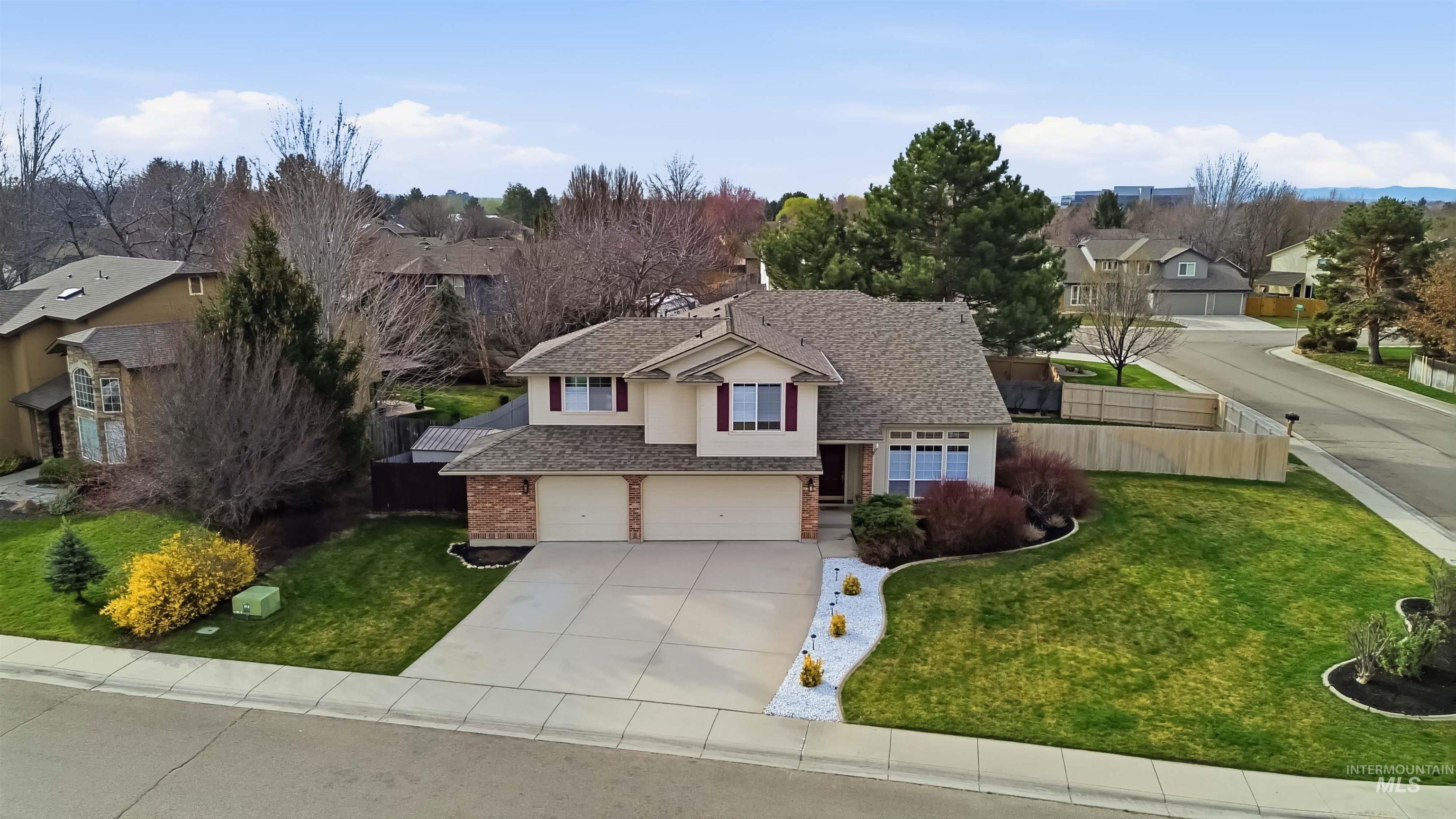 View of front of property featuring driveway, a residential view, a garage, and stucco siding