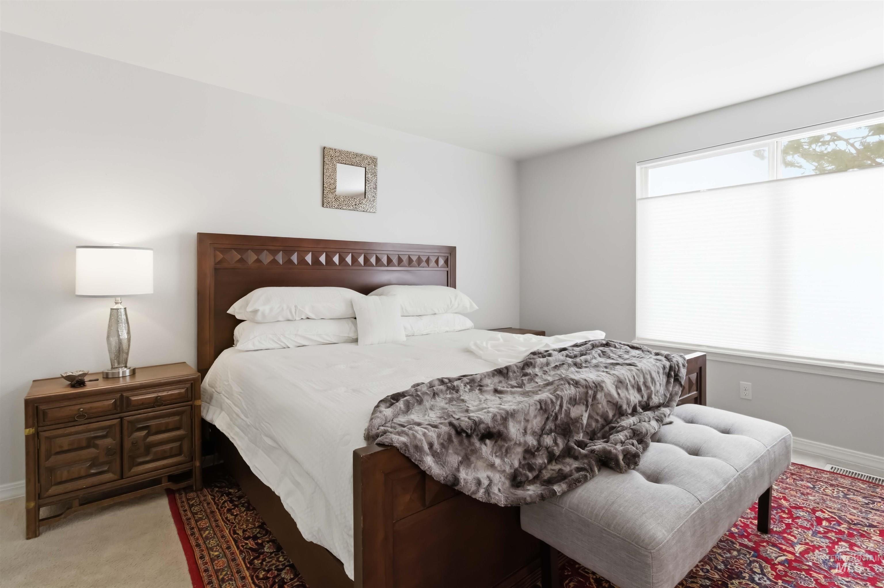 Bedroom with baseboards and light carpet