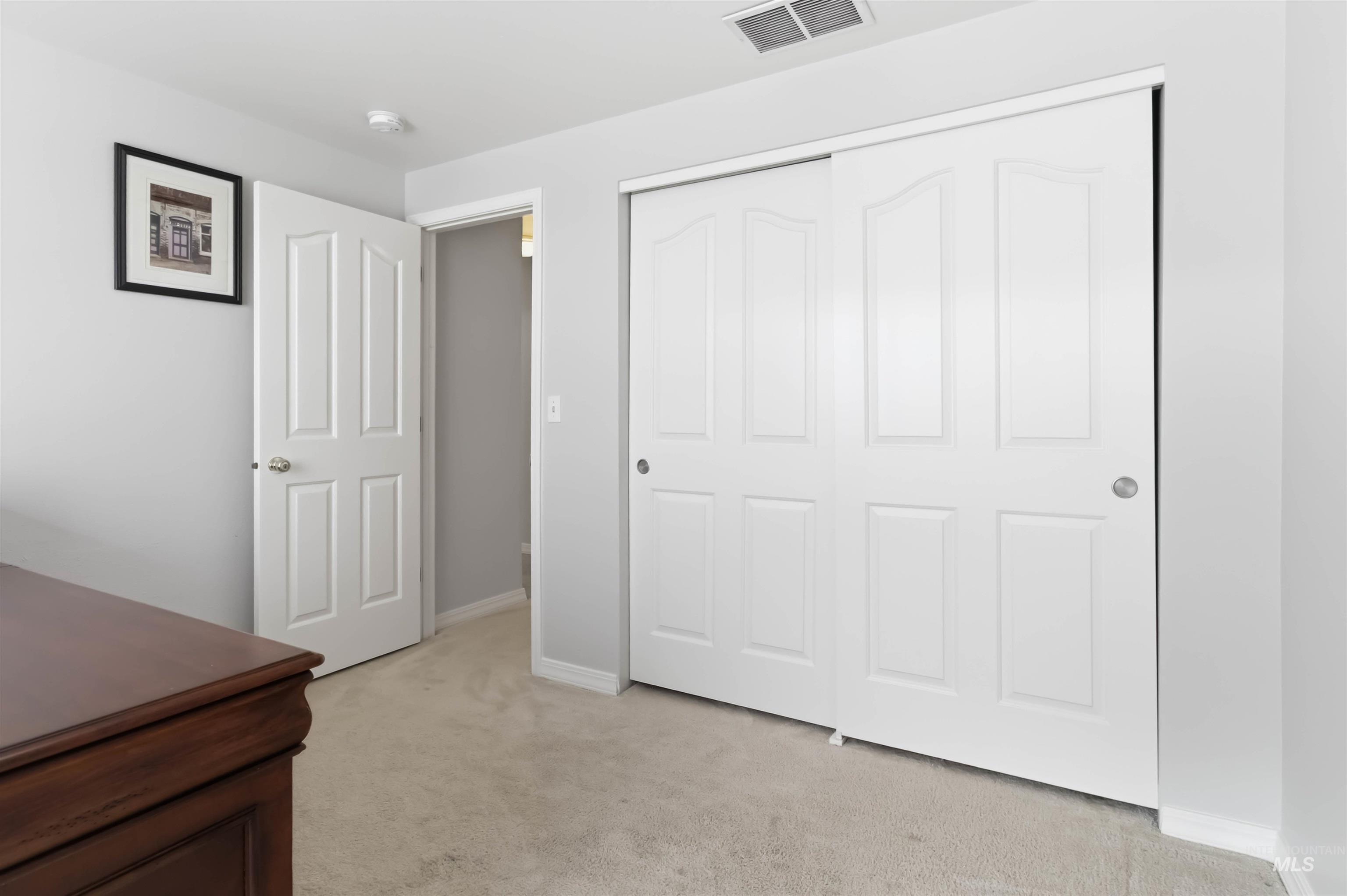 Unfurnished bedroom featuring light colored carpet and a closet