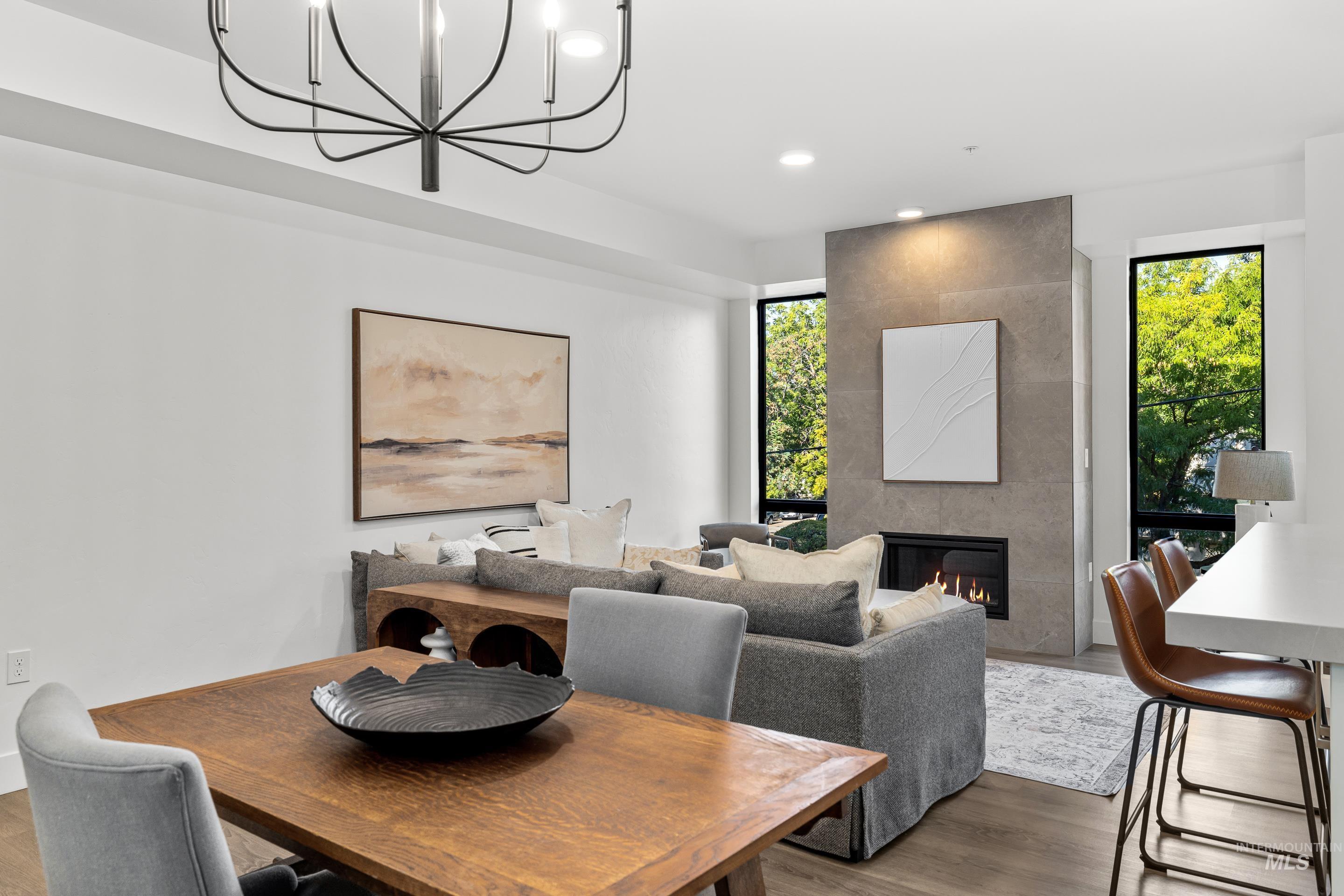 Dining area with a fireplace, wood finished floors, recessed lighting, and a chandelier