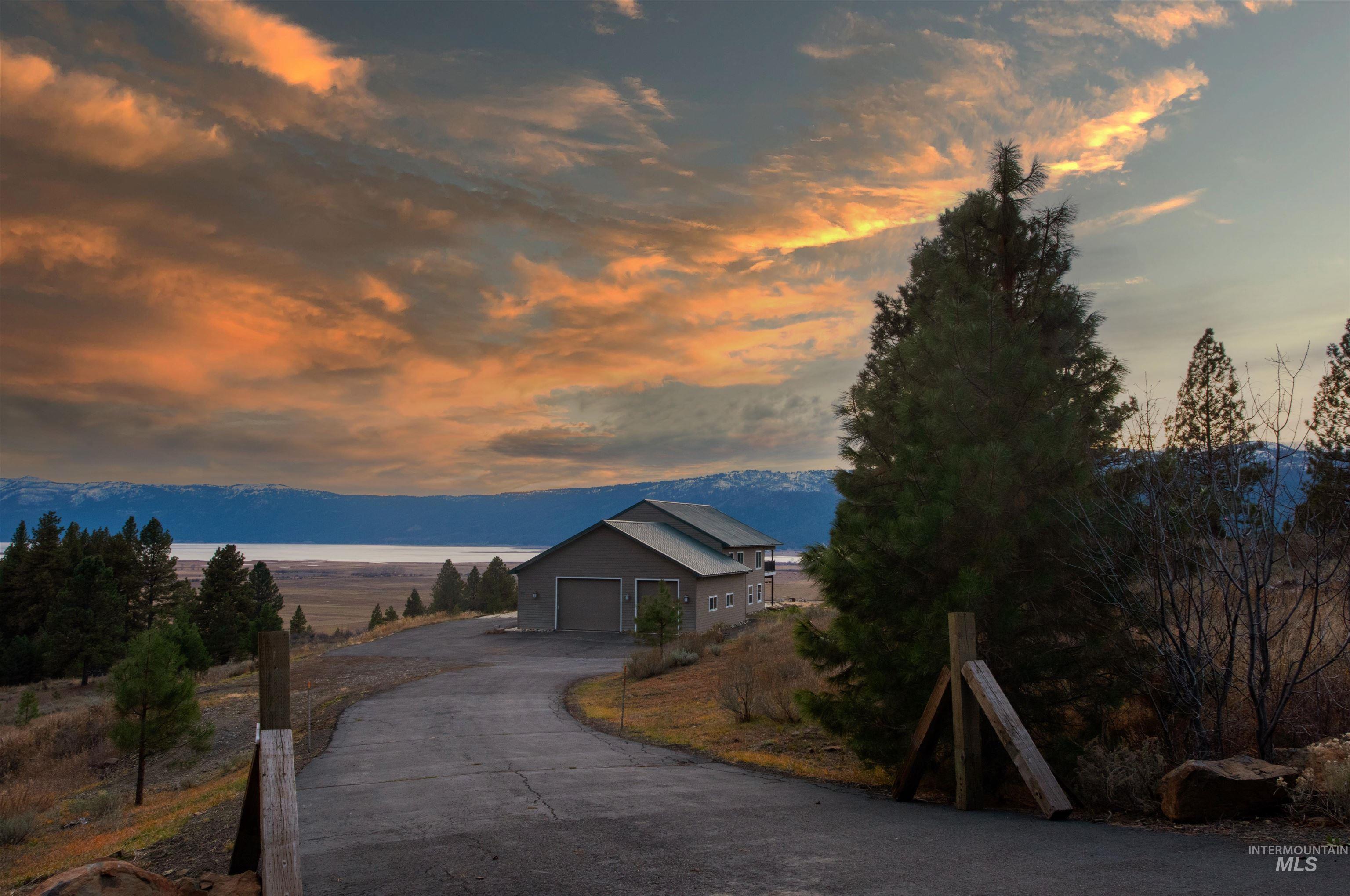 View of front facade featuring a mountain view, a garage, and asphalt driveway