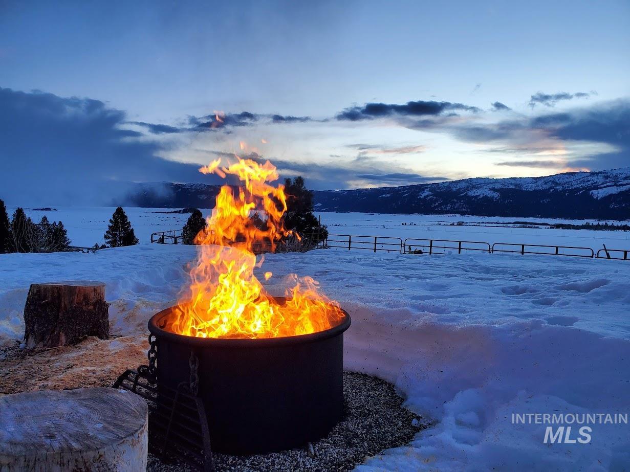Snowy yard with a fire pit and a mountain view