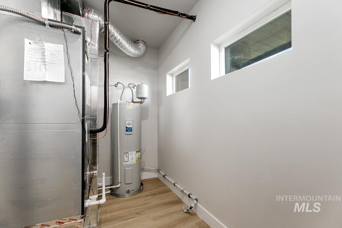Utility room featuring heating unit and water heater