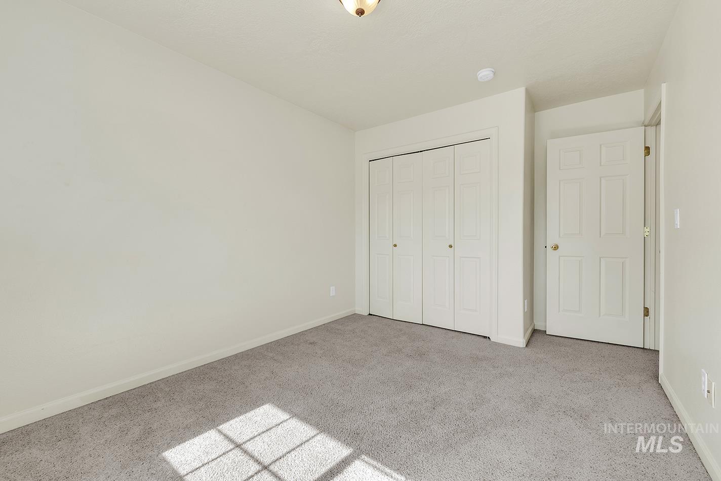 Unfurnished bedroom featuring carpet and a closet