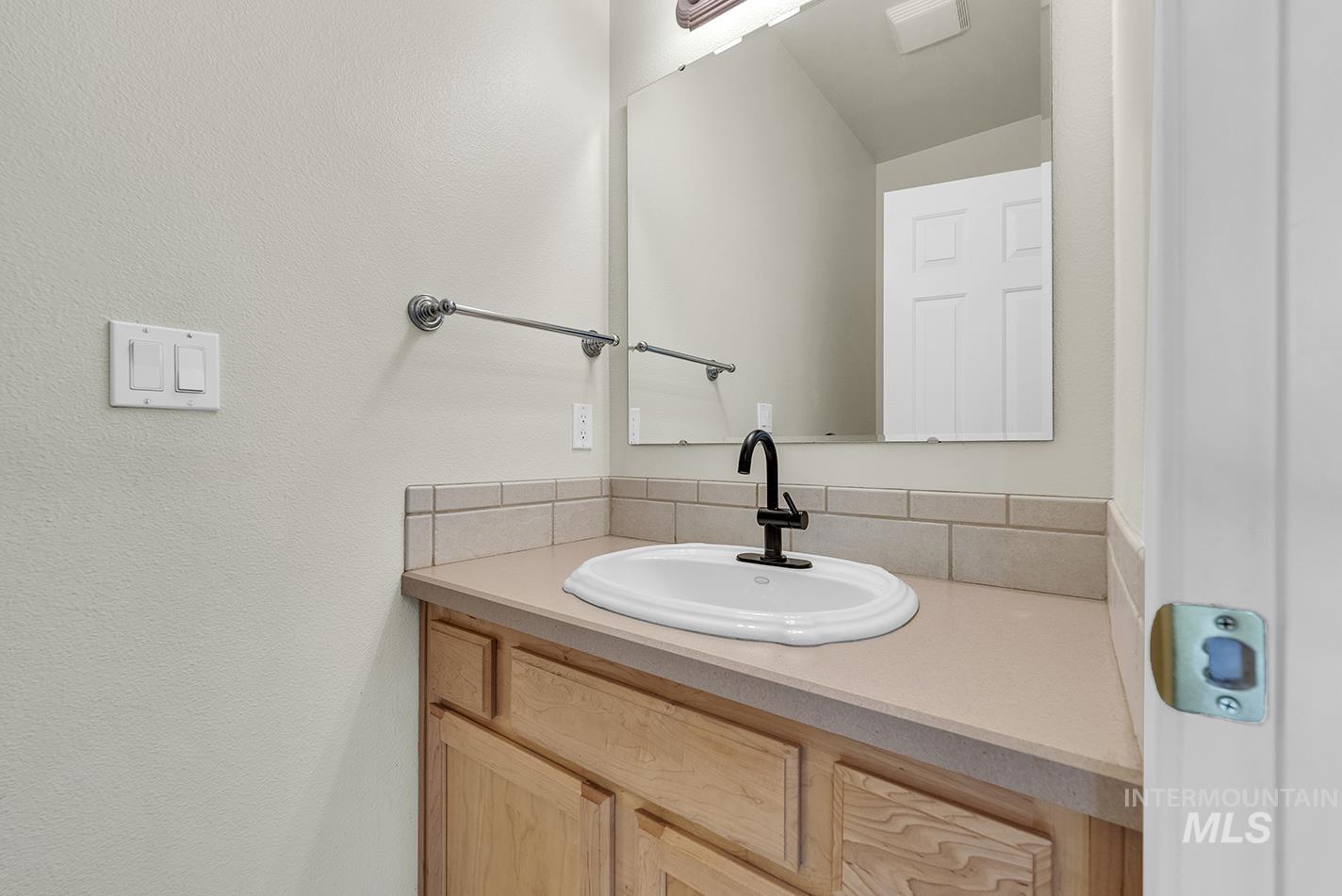 Bathroom with vanity and tasteful backsplash