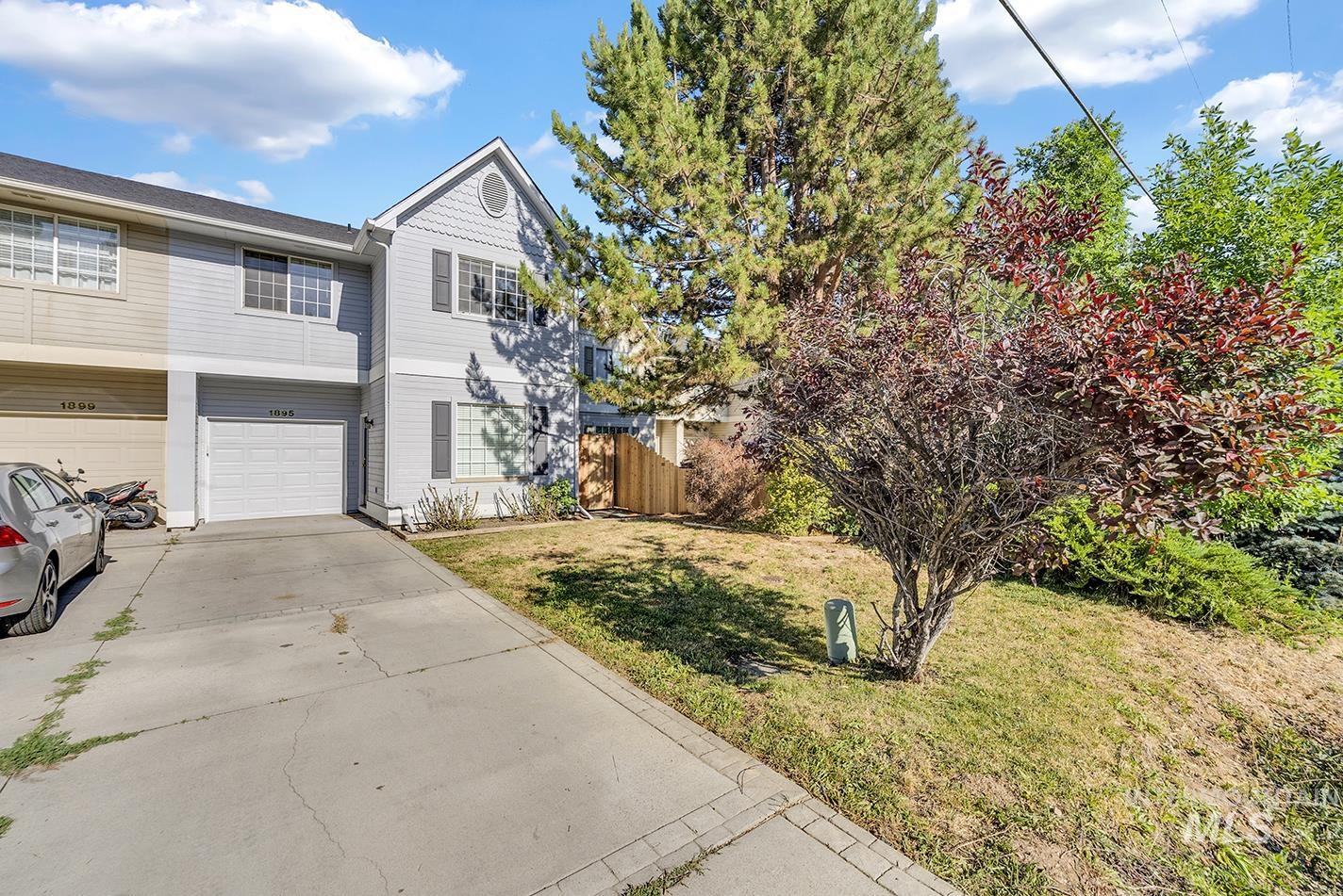 View of front of property featuring concrete driveway and an attached garage