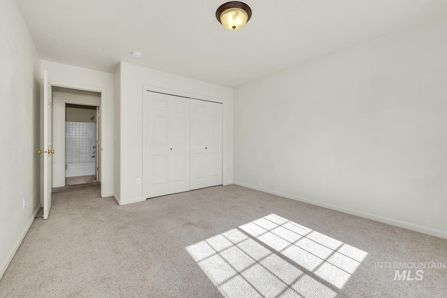 Unfurnished bedroom featuring light colored carpet and a closet