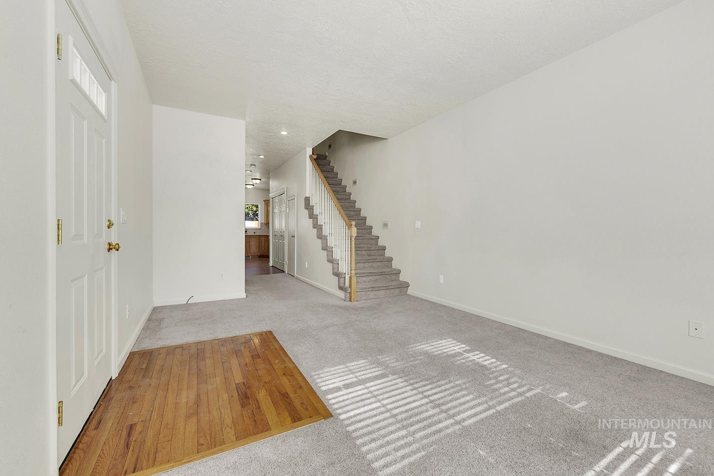 Entryway with carpet flooring and stairway