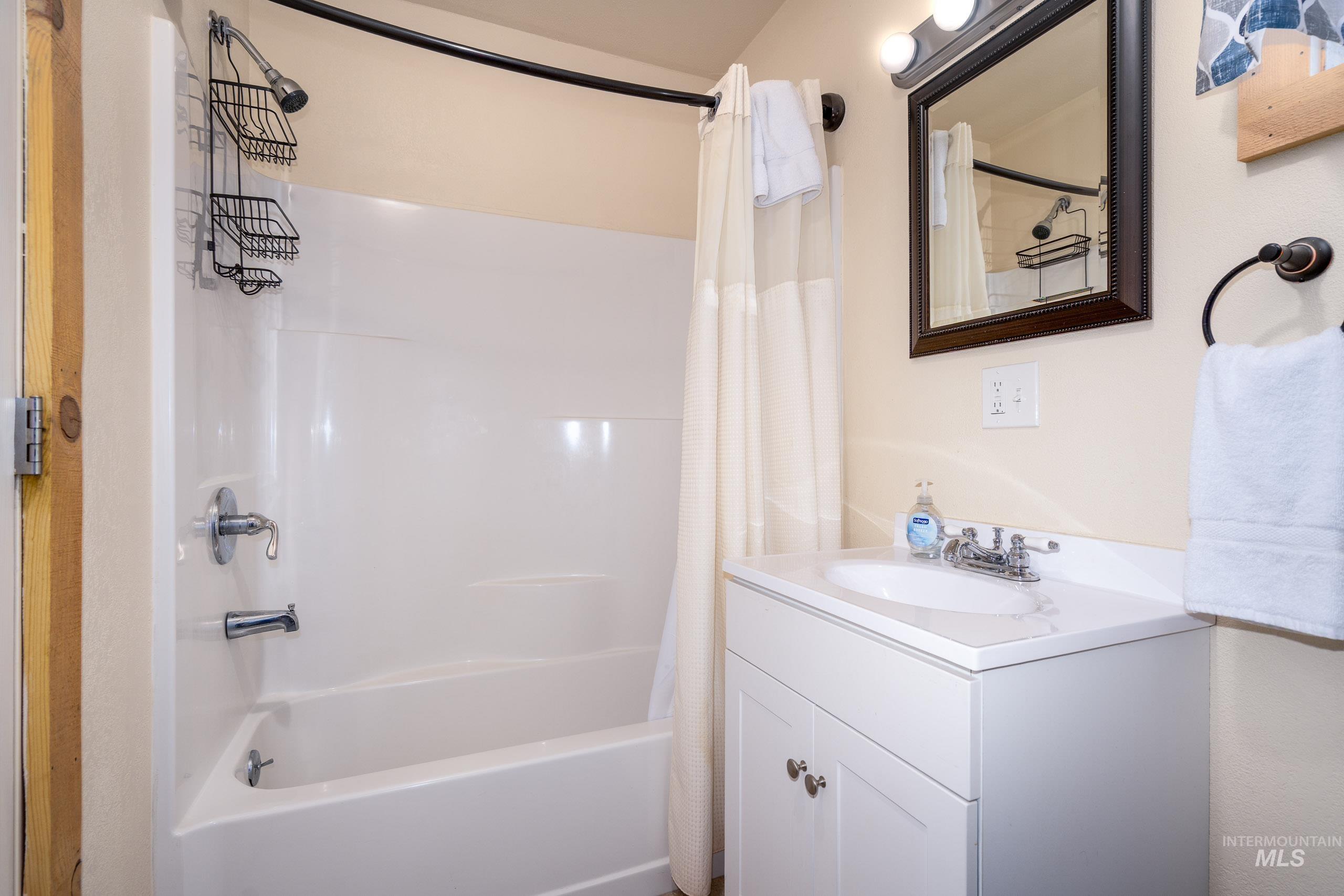 Full bath featuring shower / tub combo with curtain and vanity
