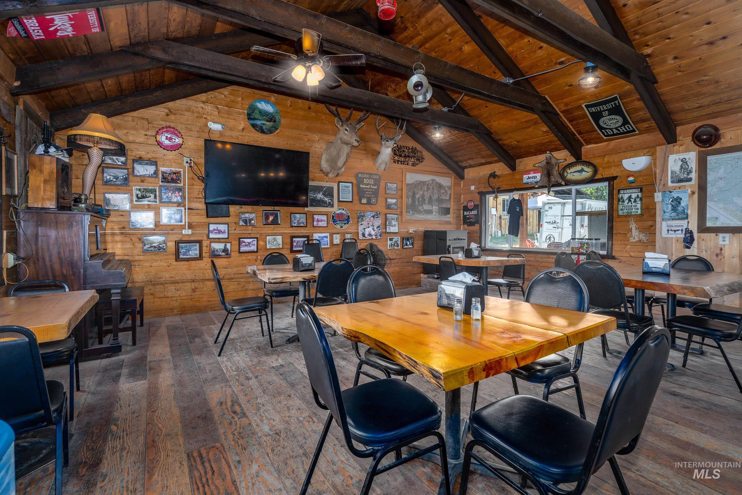 Dining room featuring wood walls, dark wood finished floors, and wood ceiling