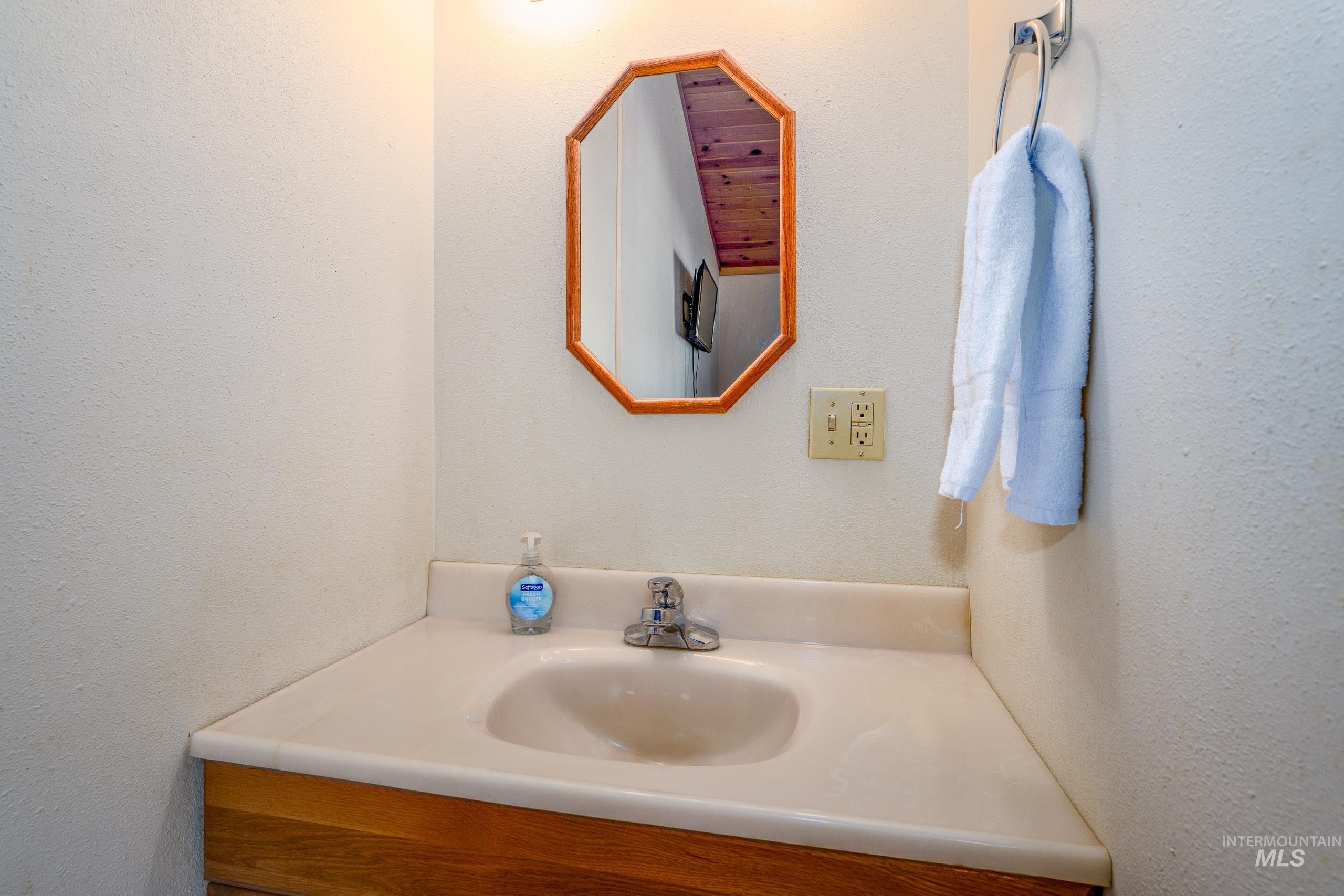Bathroom with vanity and a textured wall