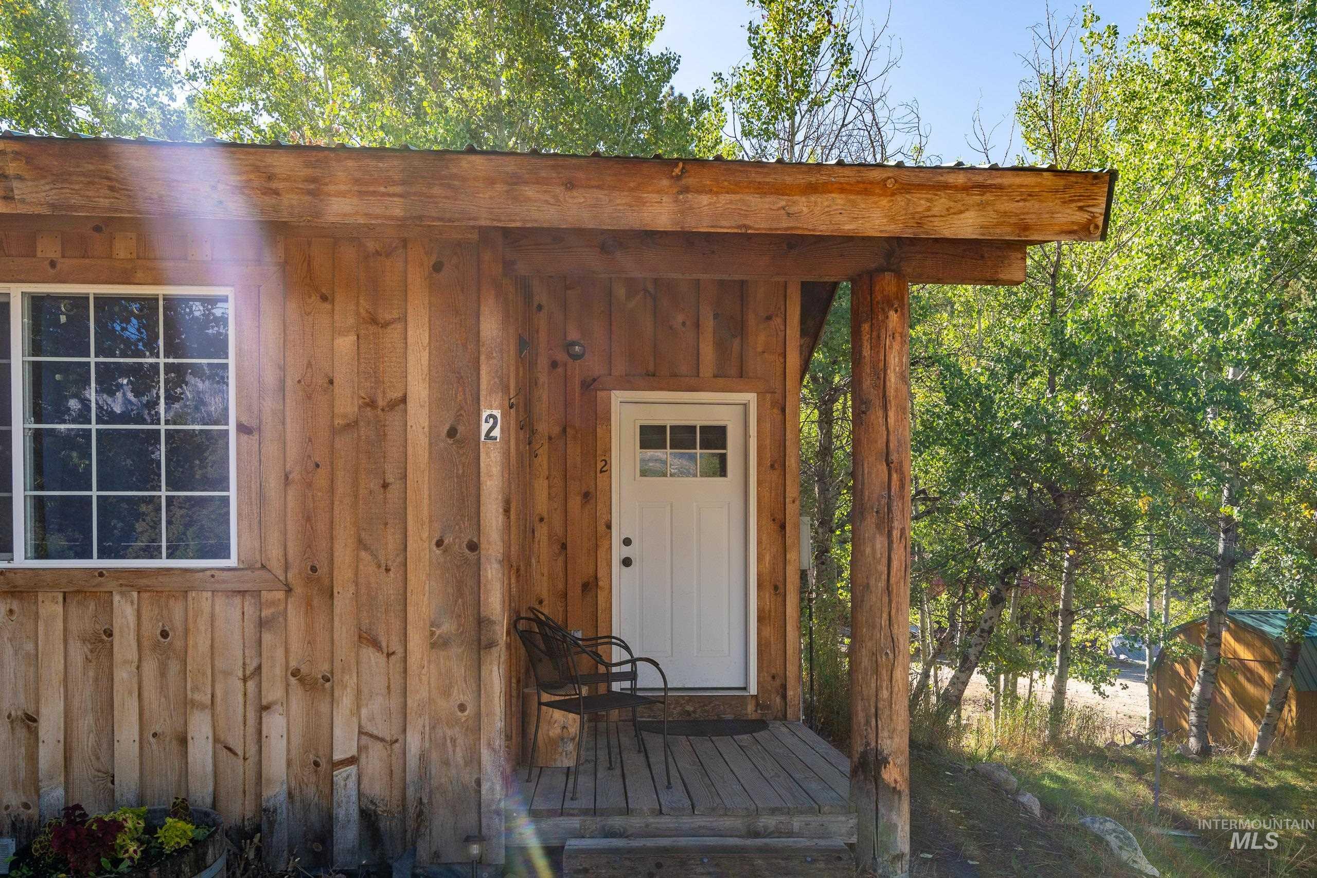 Doorway to property with board and batten siding and a deck