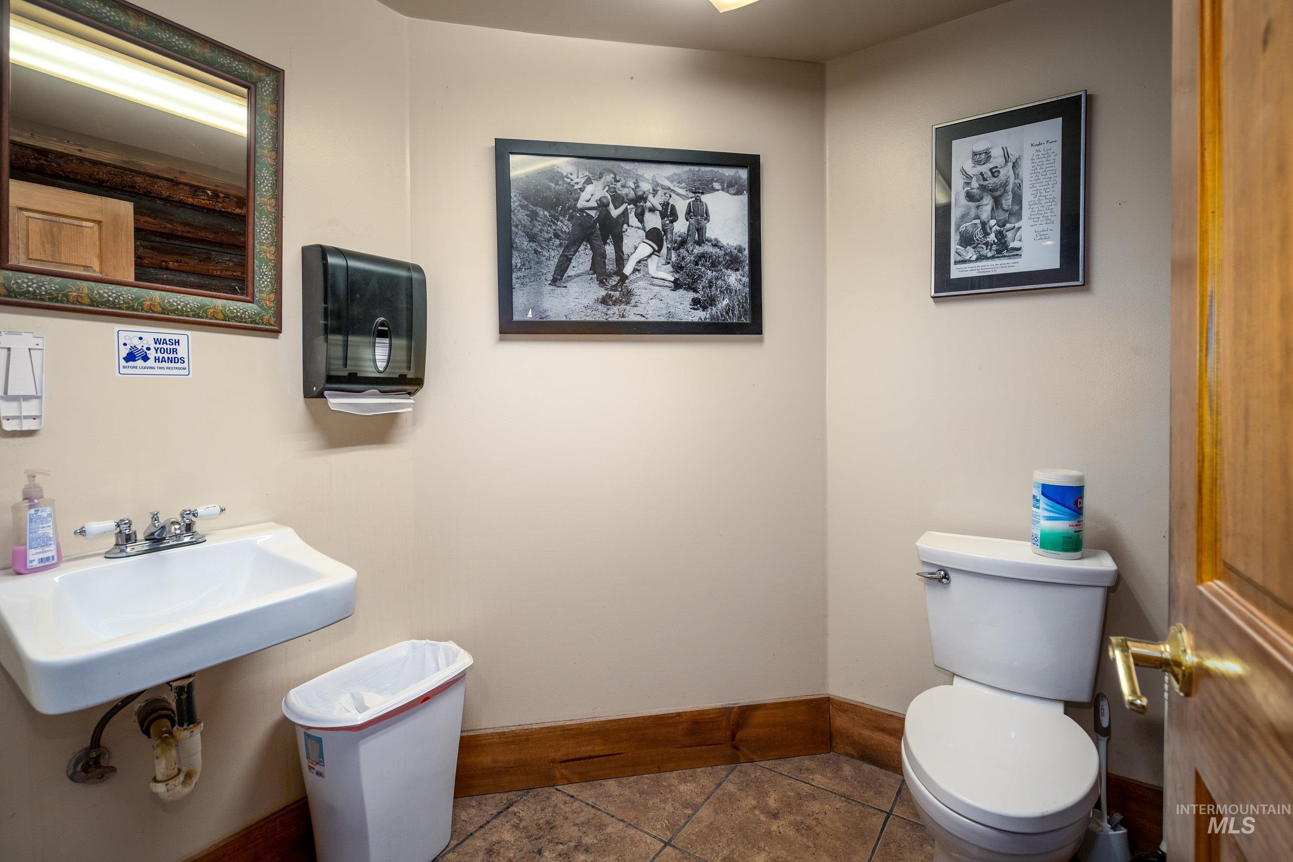 Half bath featuring toilet and dark tile patterned floors