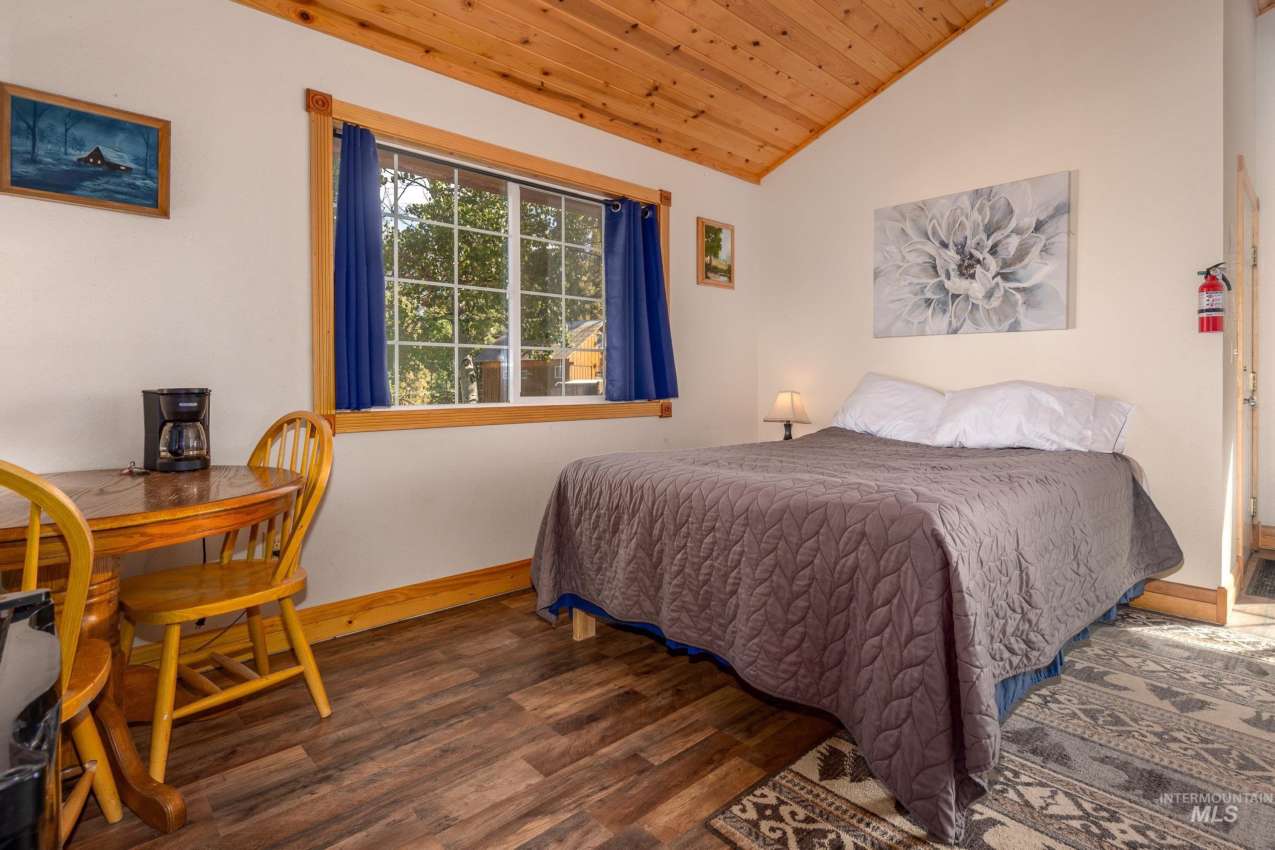 Bedroom featuring lofted ceiling, wood finished floors, and wood ceiling