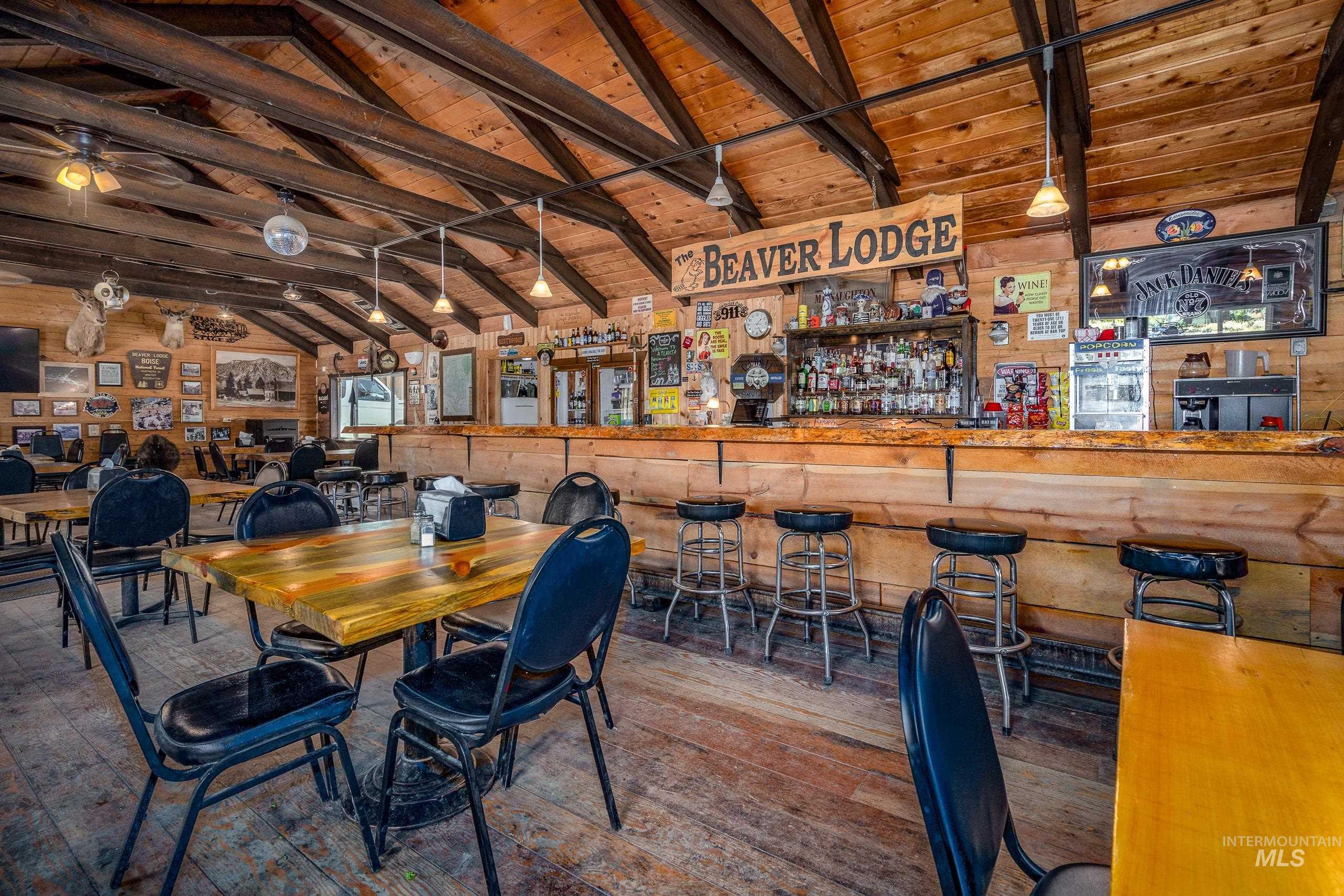 Dining space featuring wooden ceiling, wood-type flooring, a dry bar, and wooden walls