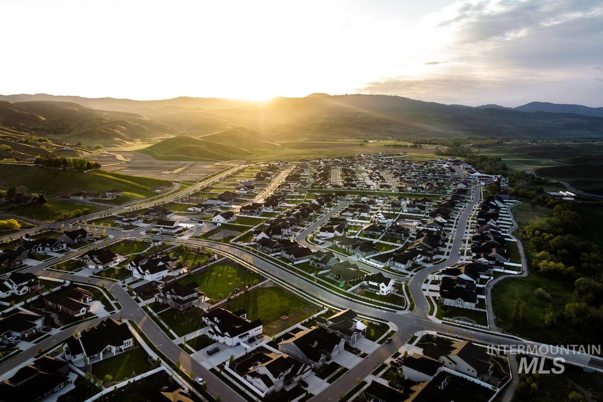 Aerial view of property and surrounding area featuring nearby suburban area and a mountain backdrop