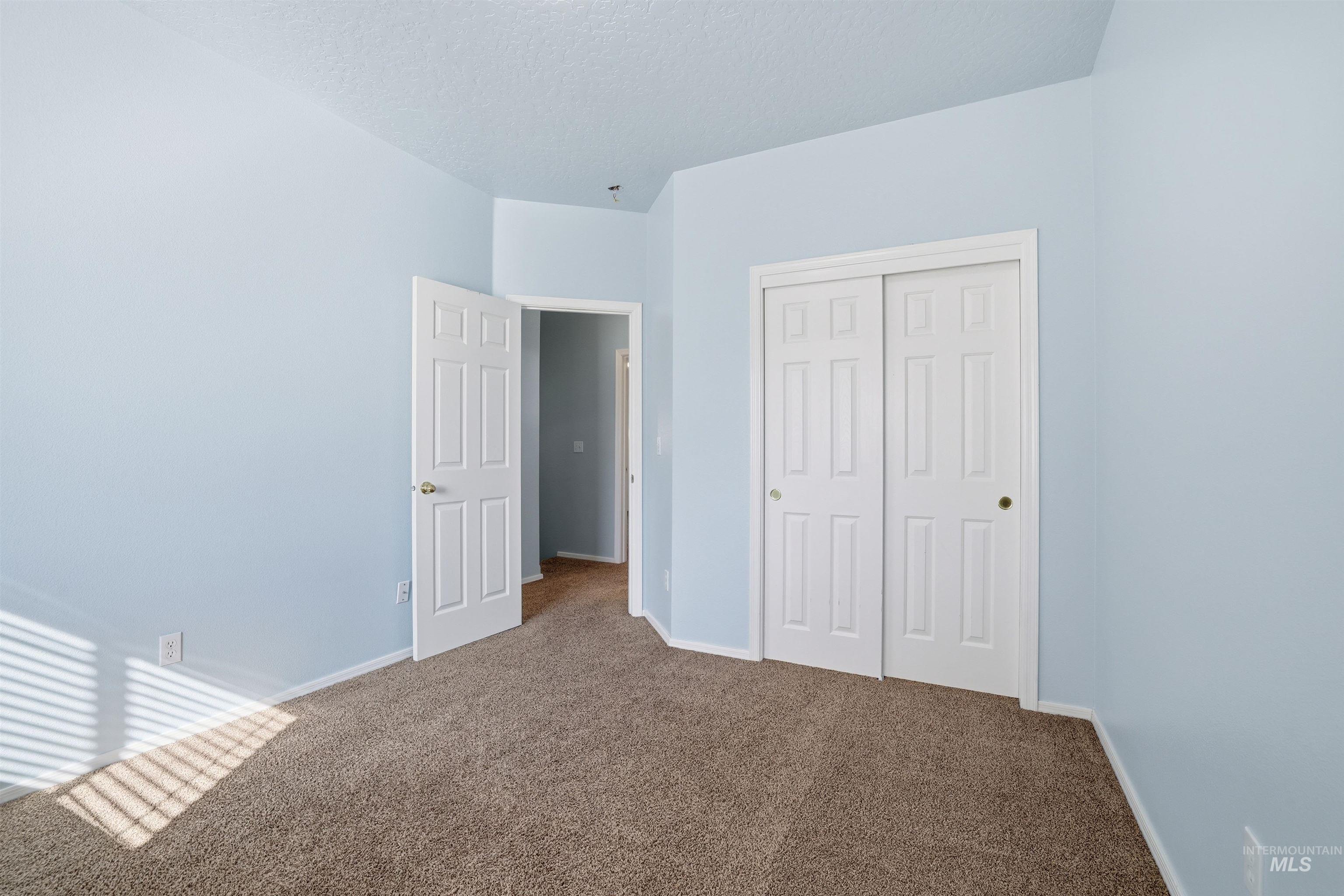 Unfurnished bedroom with carpet floors, a closet, and a textured ceiling