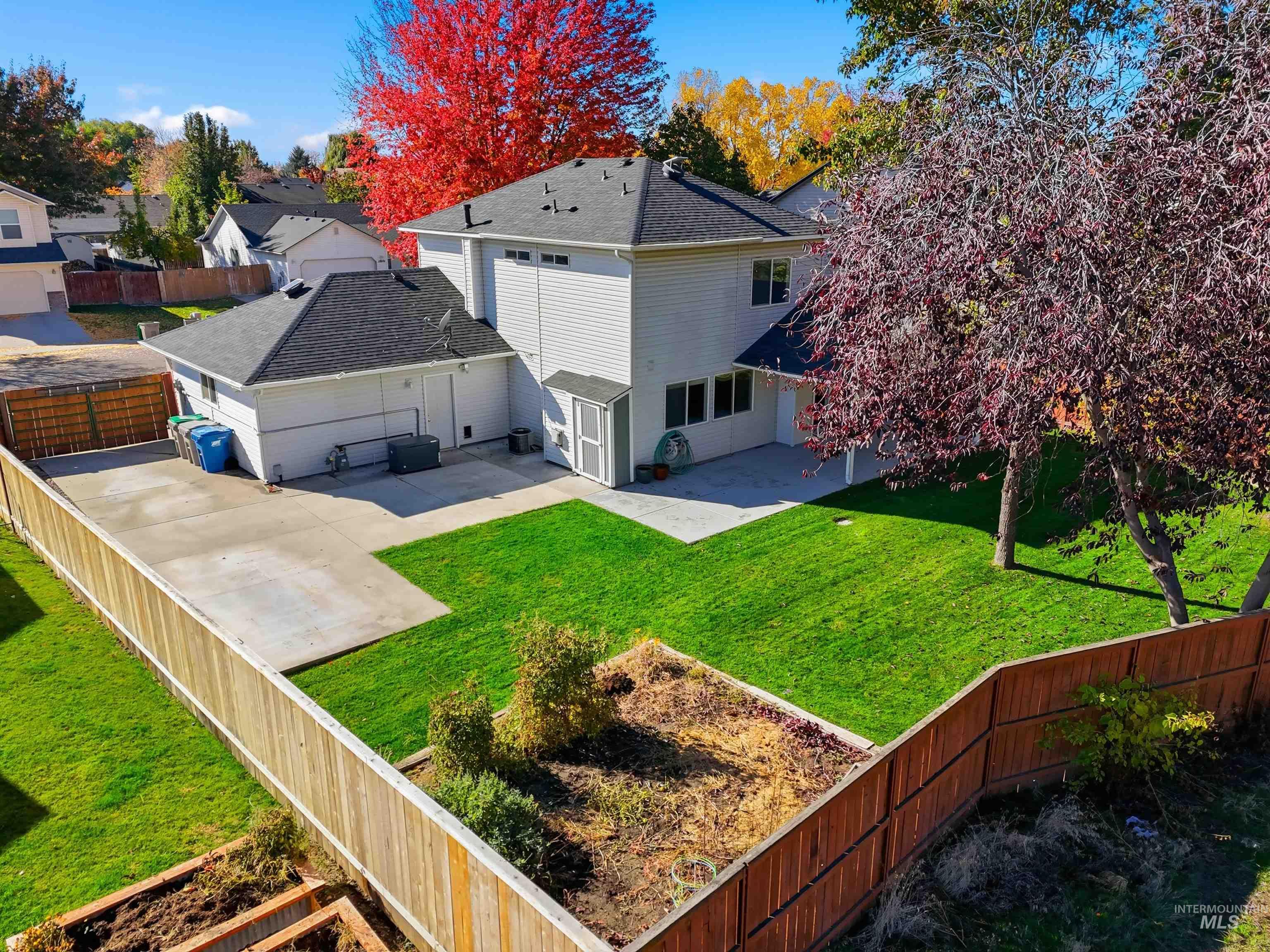 Rear view of house with a fenced backyard, a patio area, a shingled roof, and a residential view